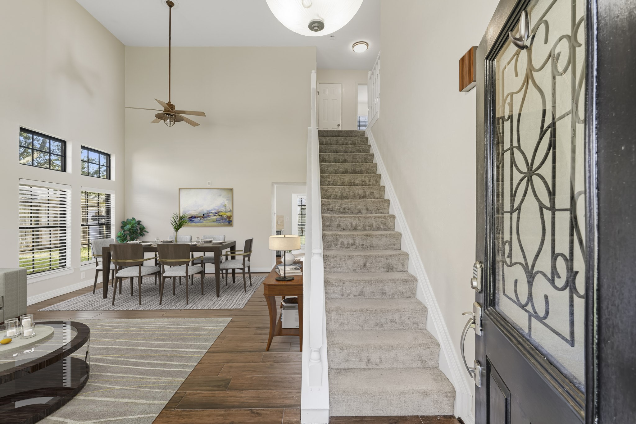 Virtually Staged: This bright, open entryway welcomes you into the home with soaring ceilings, warm wood-look flooring, and abundant natural light from multiple windows.