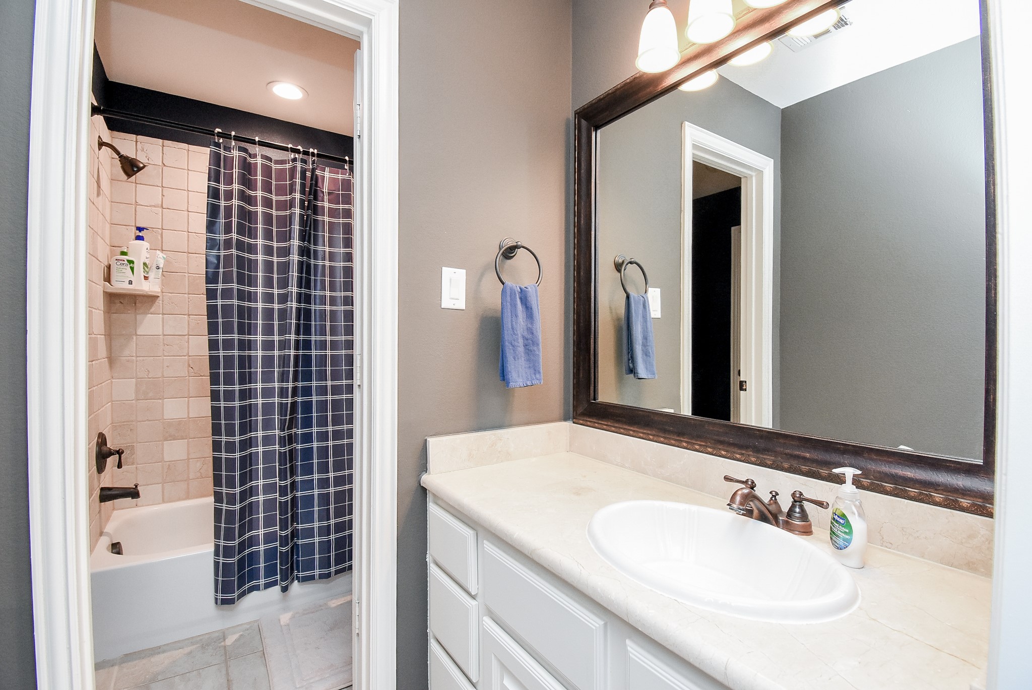 Vanity two for bedroom three shows the pretty tub/shower area. Spacious vanity and framed mirror. Lots of storage.