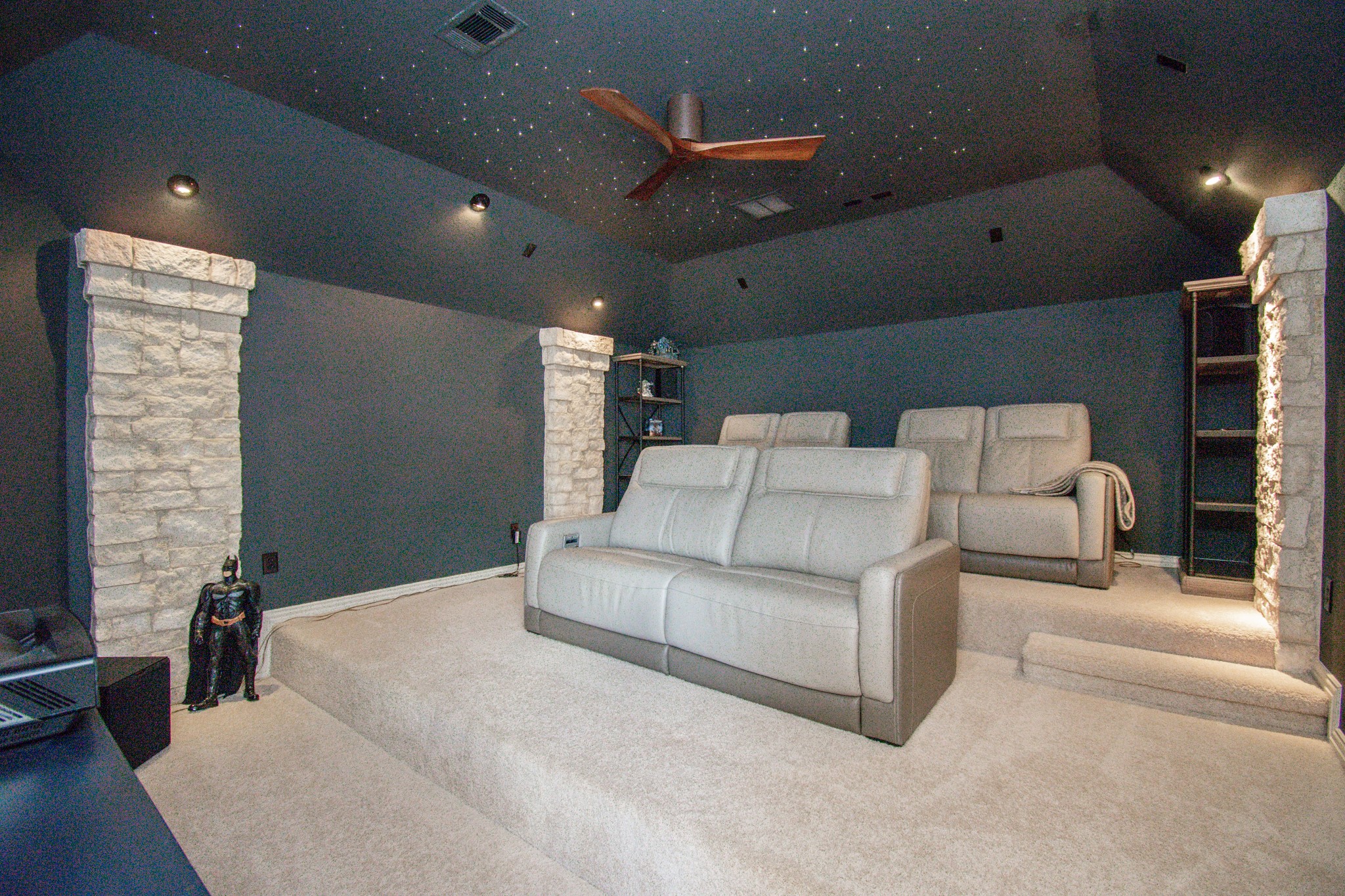 It's movie time. What a fantastic media room. Tiered seating, gambrel ceiling with tiny lights and stone columns complete this room