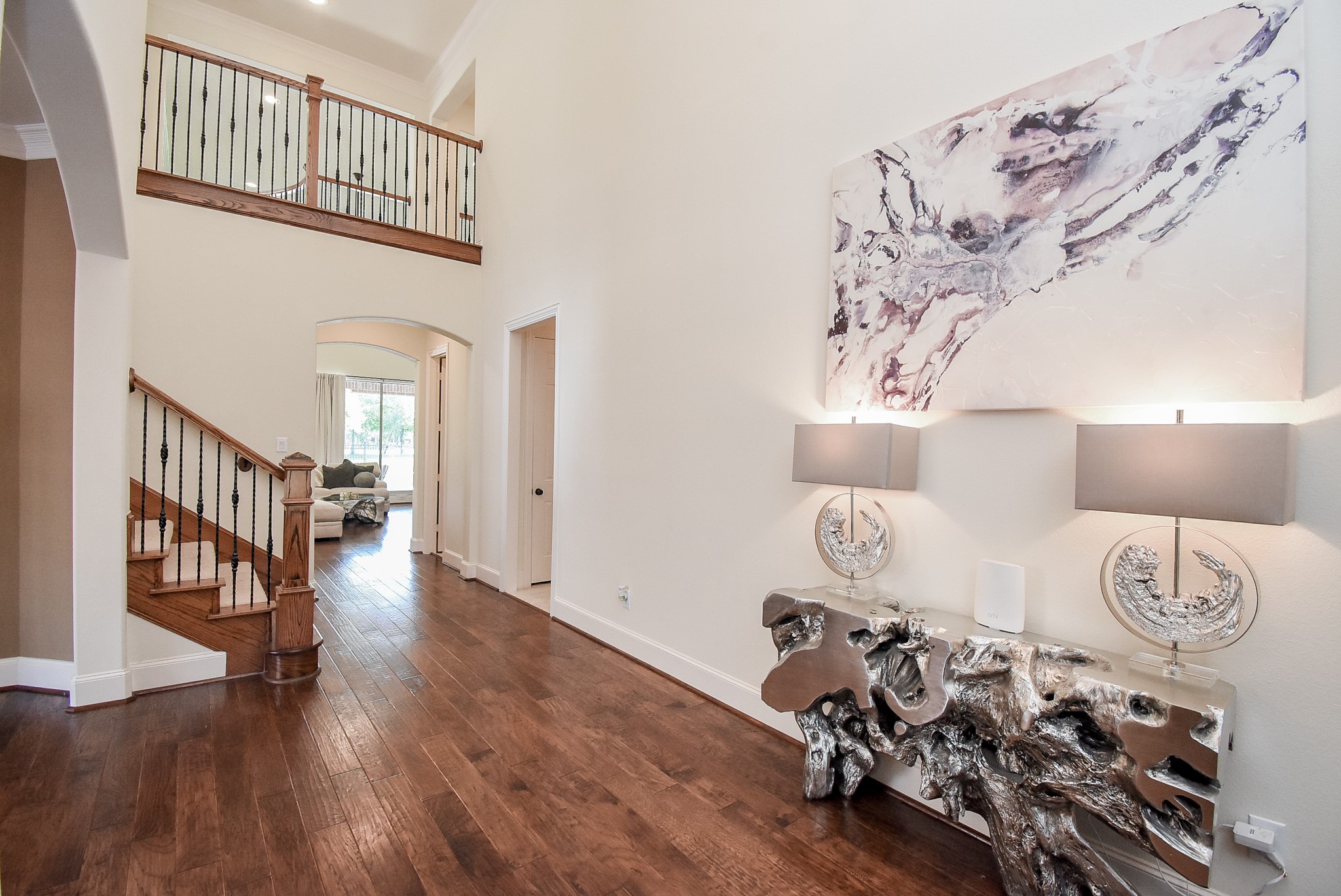 Two Story entry with warm wood flooring. Neutral wall color and great wall space.