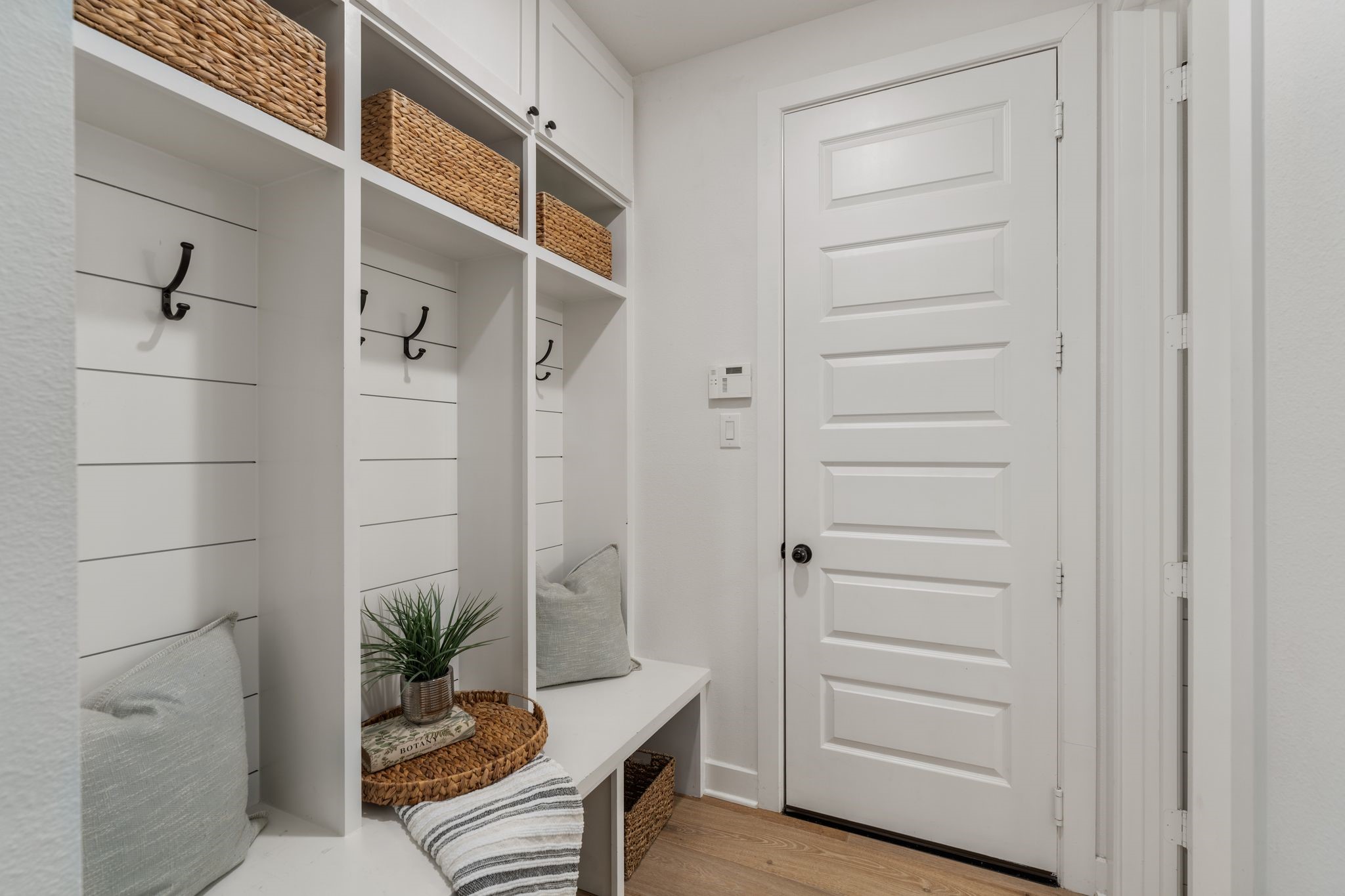 Mud room w/bench & built-ins and custom wall...all leading to the 3 car tandem garage w/epoxy floors