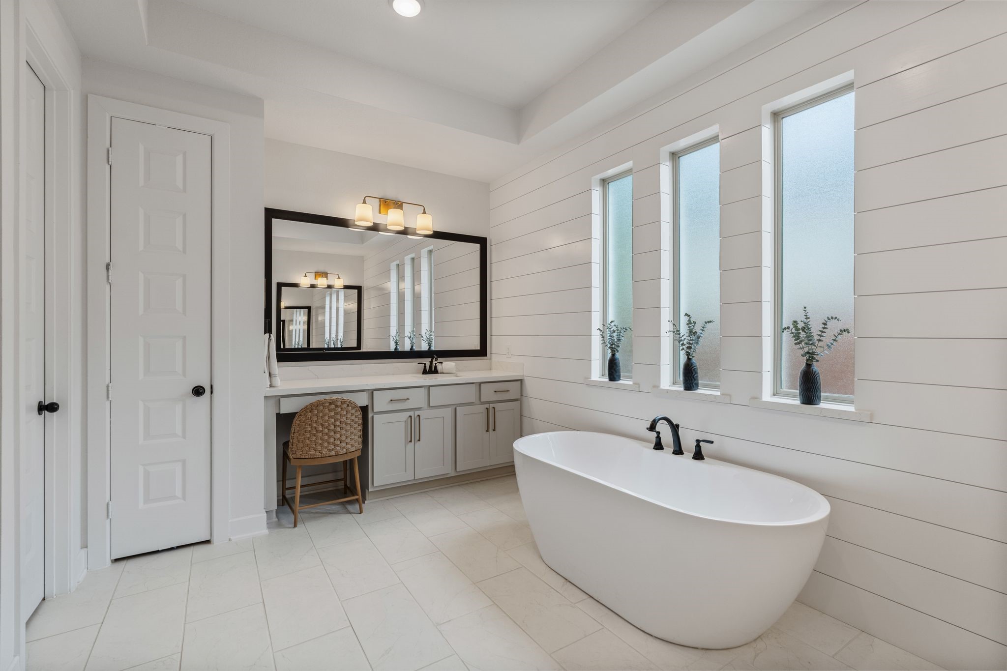 Dual vanities with a dedicated makeup station, designer lighting, oversized walk-in shower, and beautiful natural light from three windows, creating the ultimate private retreat.