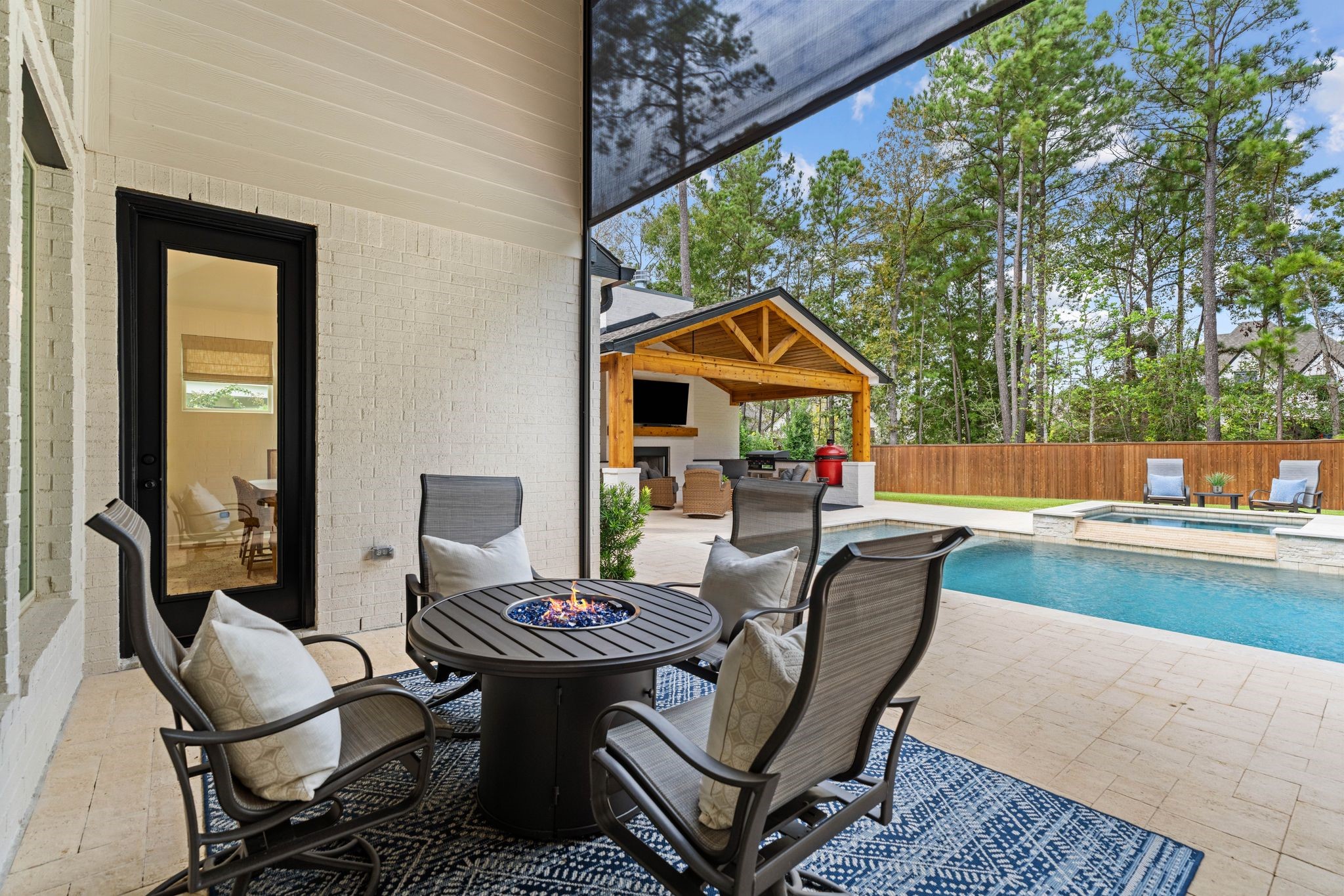Inviting covered patio featuring a premium motorized retractable screen, offering shade, comfort, and an added safety barrier to the pool.