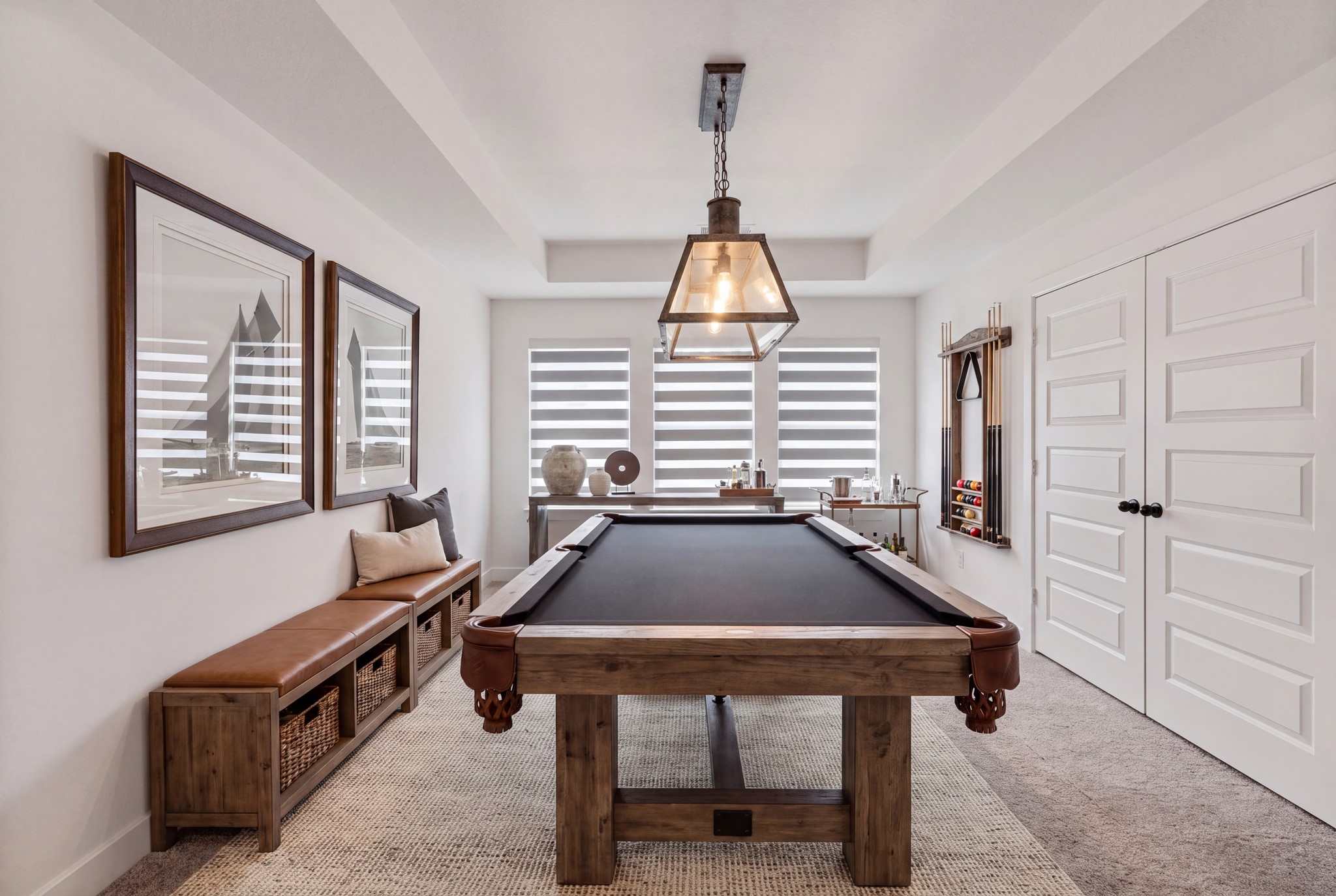 Versatile game room featuring elegant tray ceilings, custom window shades, and ample space for a billiards tableperfect for entertaining, relaxing, and hosting unforgettable nights!
