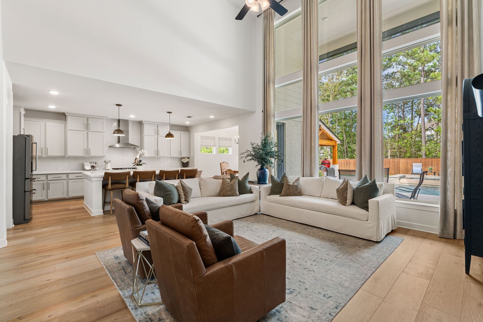 Seamlessly flowing into designer kitchen and dining area, this stunning living space showcases breathtaking views of the private backyard, pool, spa, and serene wooded greenbeltcreating the perfect setting for sophisticated living and effortless entertaining!