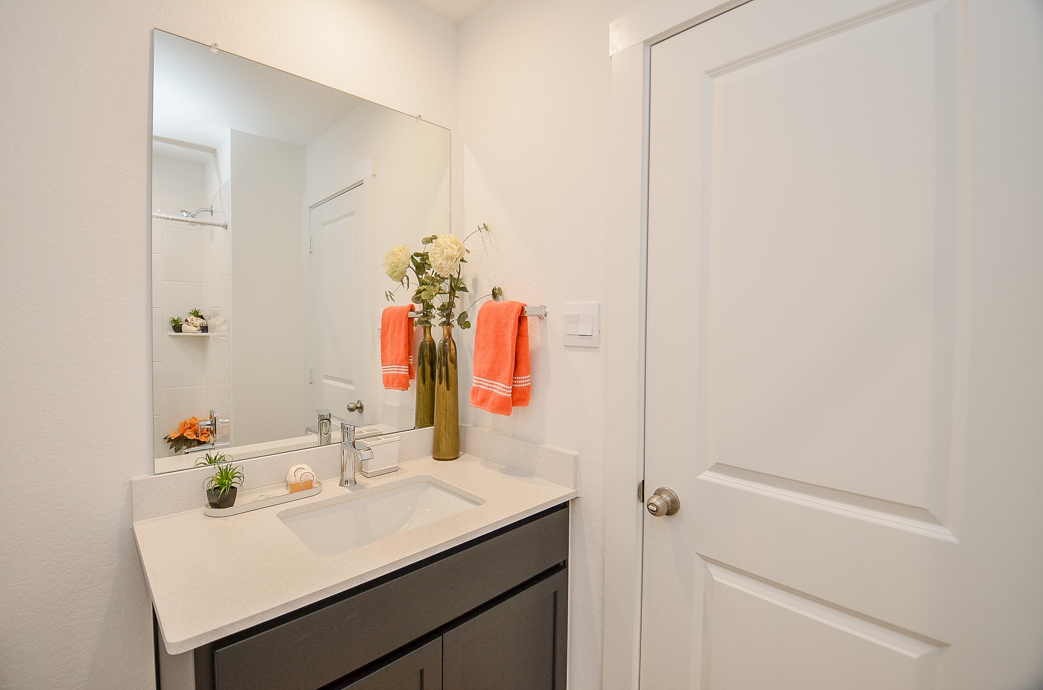 Sleek bathroom featuring a modern vanity with ample countertop space complemented by a large mirror.