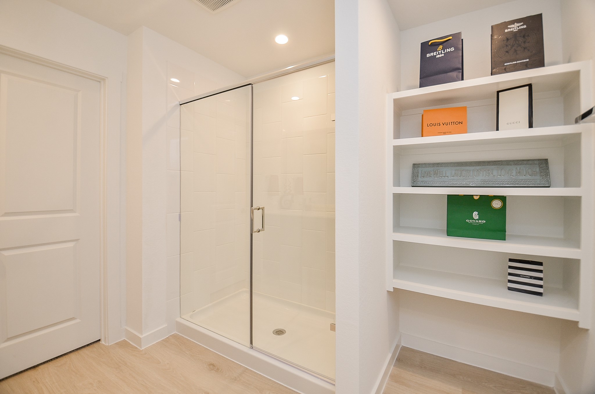 Modern bathroom featuring a sleek glass-enclosed shower and built-in shelving for stylish storage.