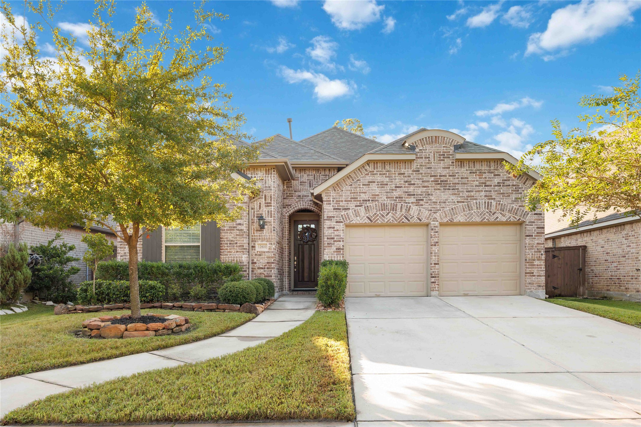 This charming home features a welcoming brick exterior, a two-car garage, and a neatly landscaped front yard with a well-maintained lawn and mature trees. The pathway leads to an elegant front door, creating a warm and inviting entrance. This charming home features a welcoming brick exterior, a two-car garage, and a neatly landscaped front yard with a well-maintained lawn and mature trees. The pathway leads to an elegant front door, creating a warm and inviting entrance.