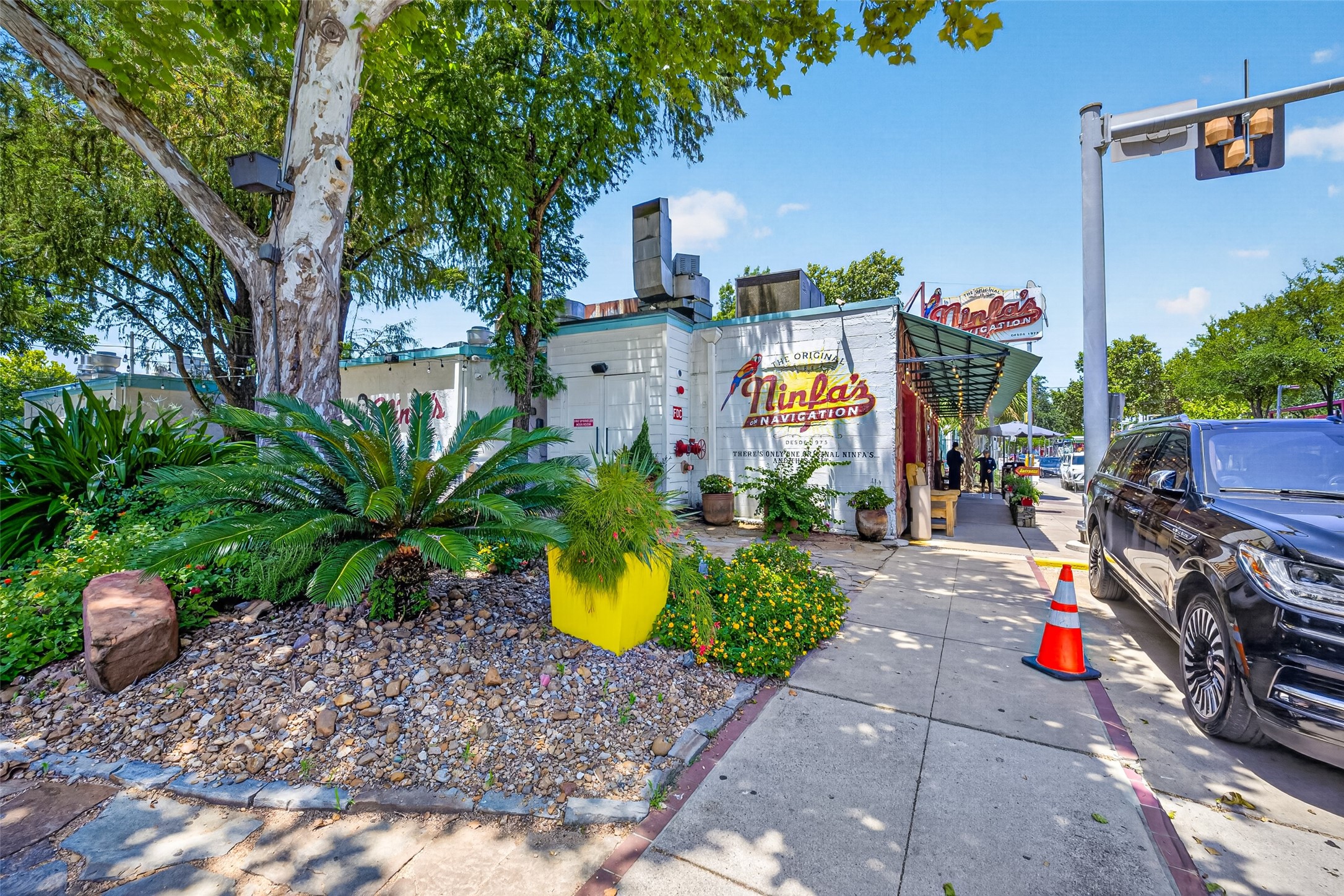 Ninfas a charming eatery with a vintage vibe, surrounded by lush greenery and vibrant planters, offering a welcoming sidewalk setting.