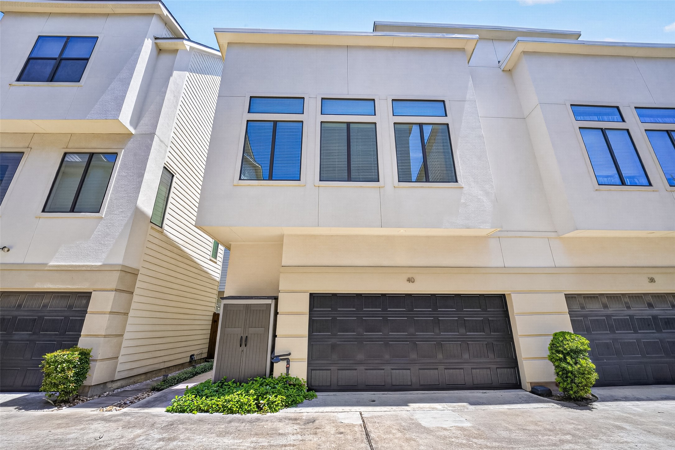 Modern townhouse featuring a sleek facade with large windows and an attached two-car garage, offering ample natural light and convenient parking. Modern townhouse featuring a sleek facade with large windows and an attached two-car garage, offering ample natural light and convenient parking.