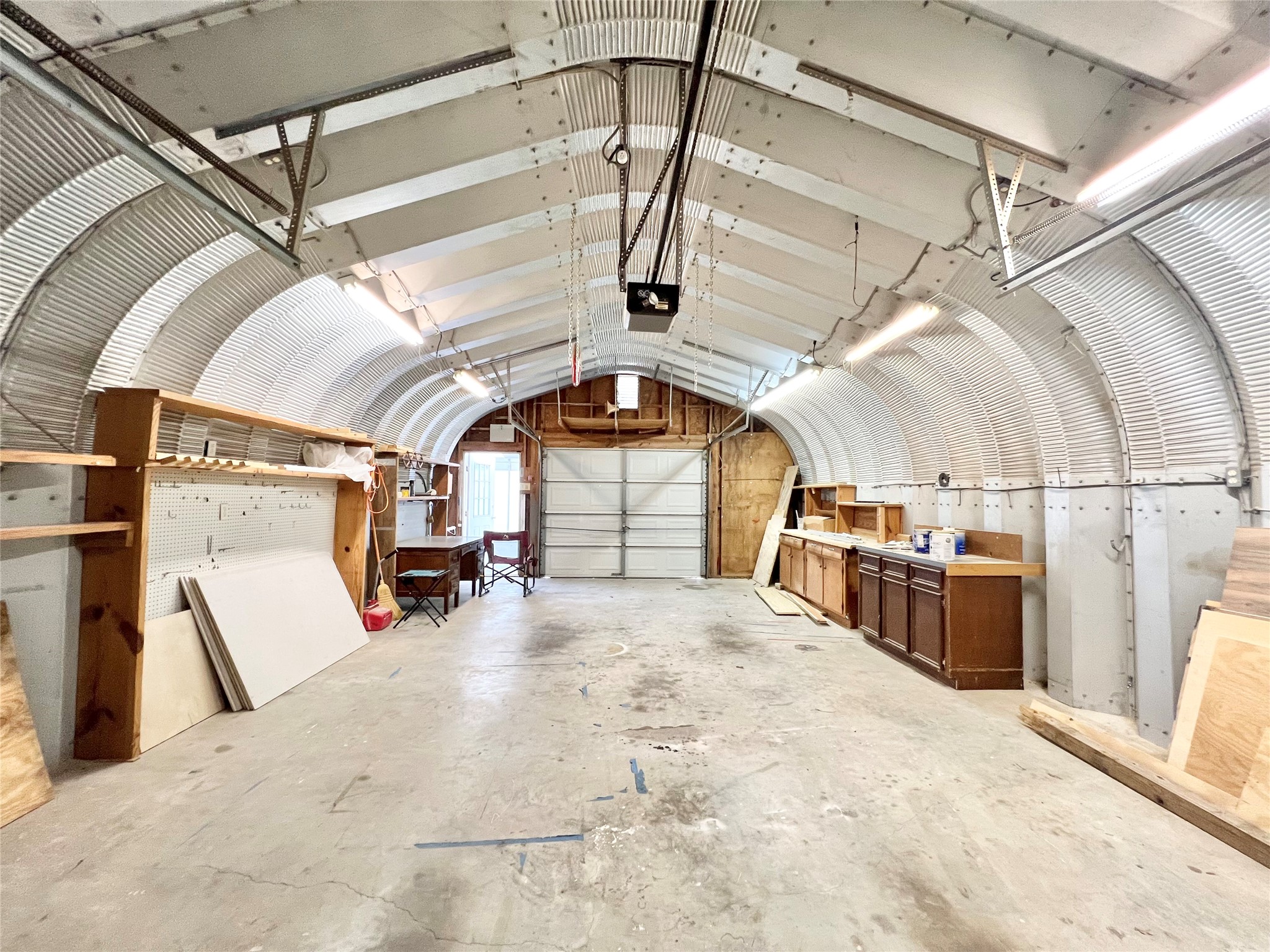Electric with plenty of lights, additional cabinets and workspace stay. Auto Garage Door Opener and an additional garage door on the other end to pull through and for cross ventilation.