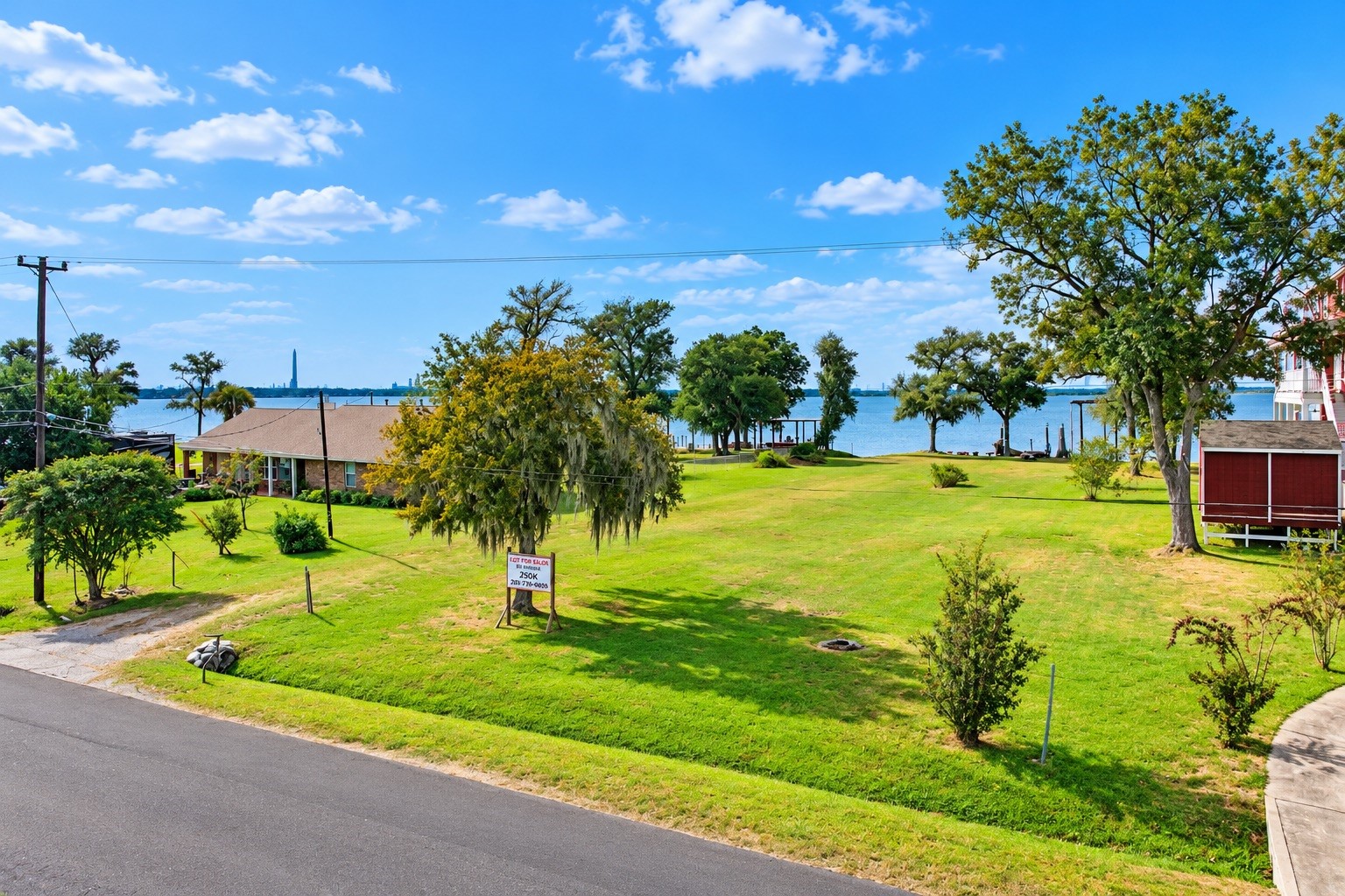 Expansive waterfront property with lush greenery, offering stunning views of the serene lake and easy access to outdoor activities.