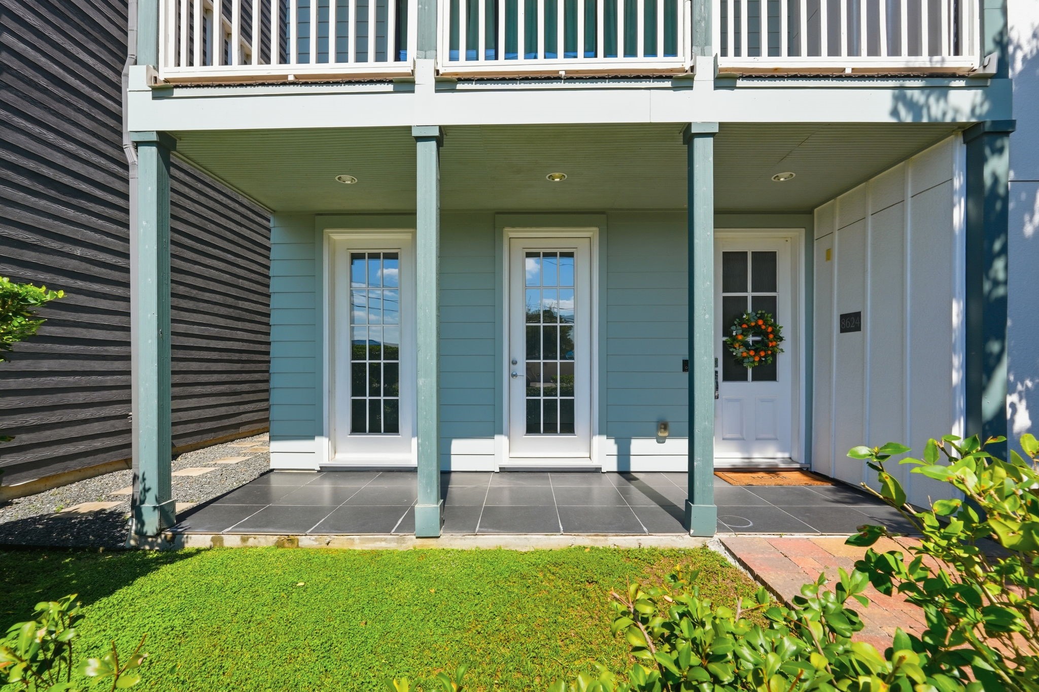 Sweet front porch with plenty of green space.