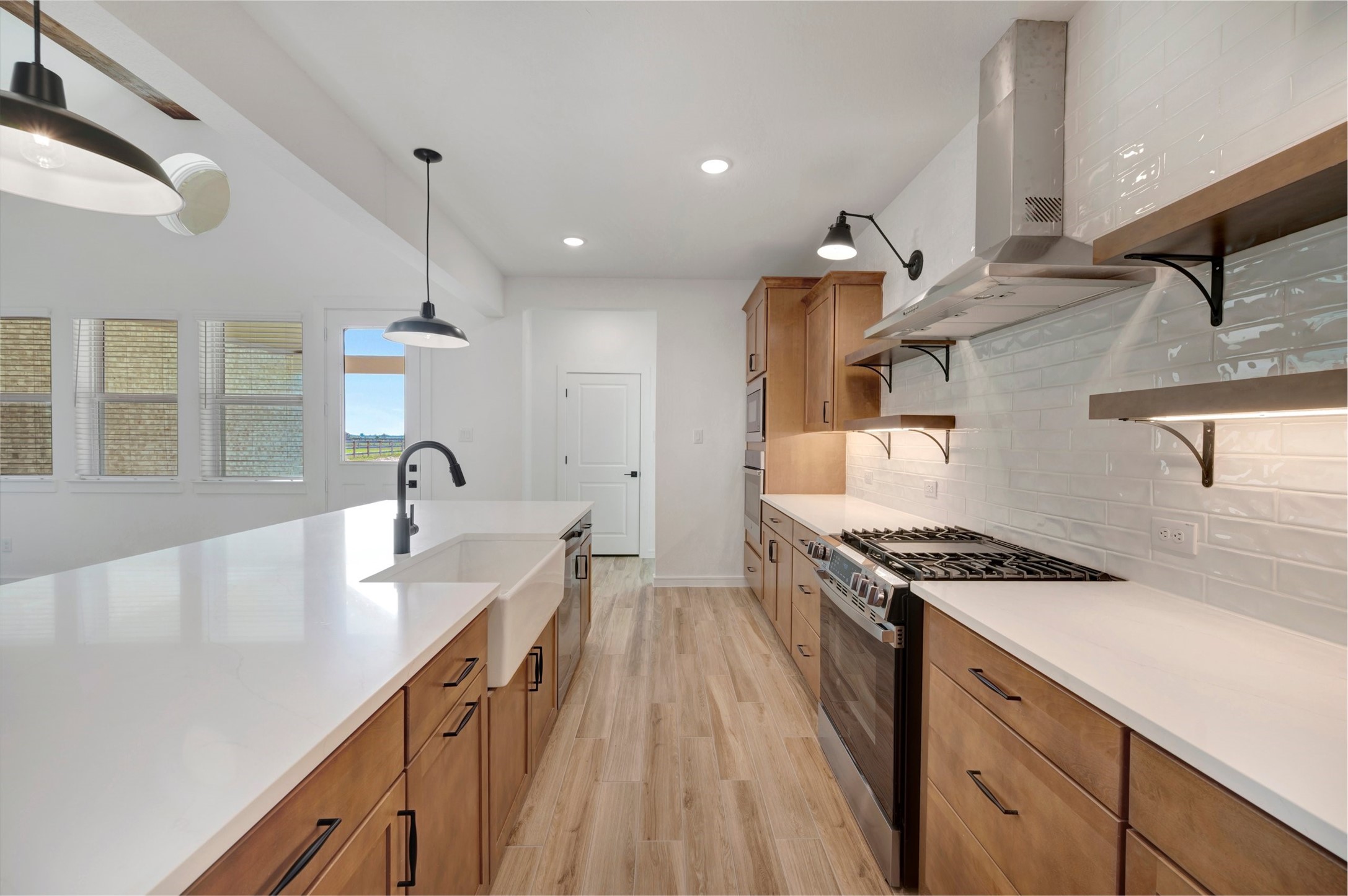 Stylish kitchen with light stain cabinets and floating shelves