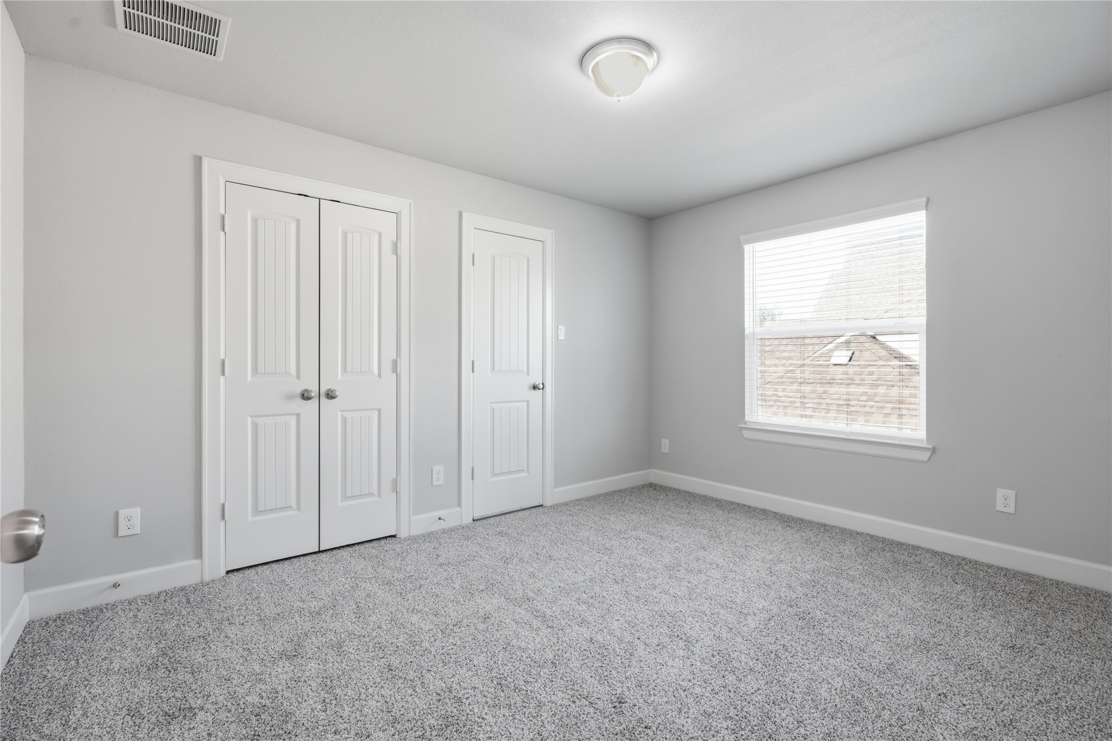 Bright upstairs secondary bedroom with a large window providing plenty of natural light.