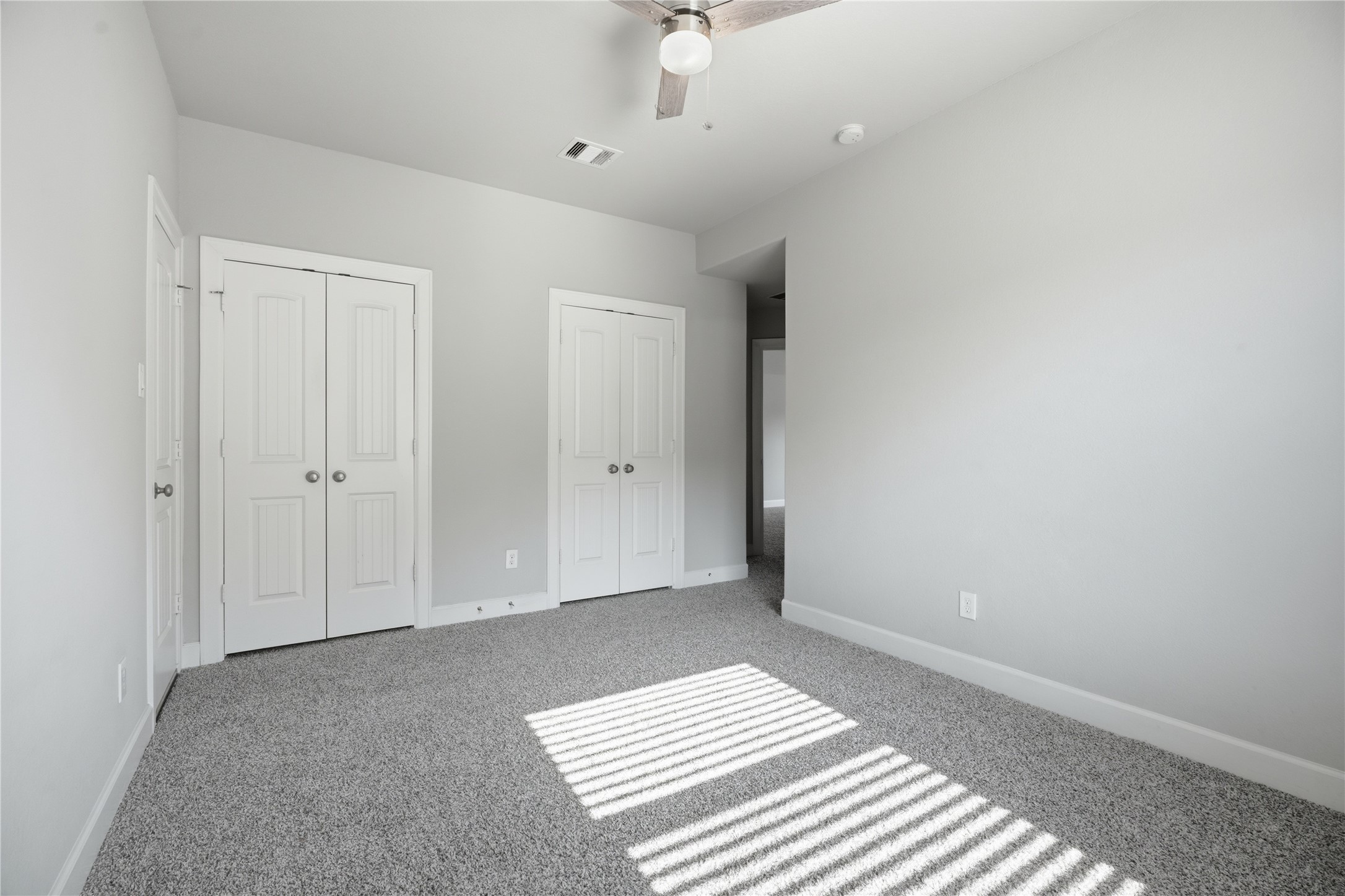 Spacious secondary bedroom featuring abundant natural light, two closets, and its own private en-suite bathroom.