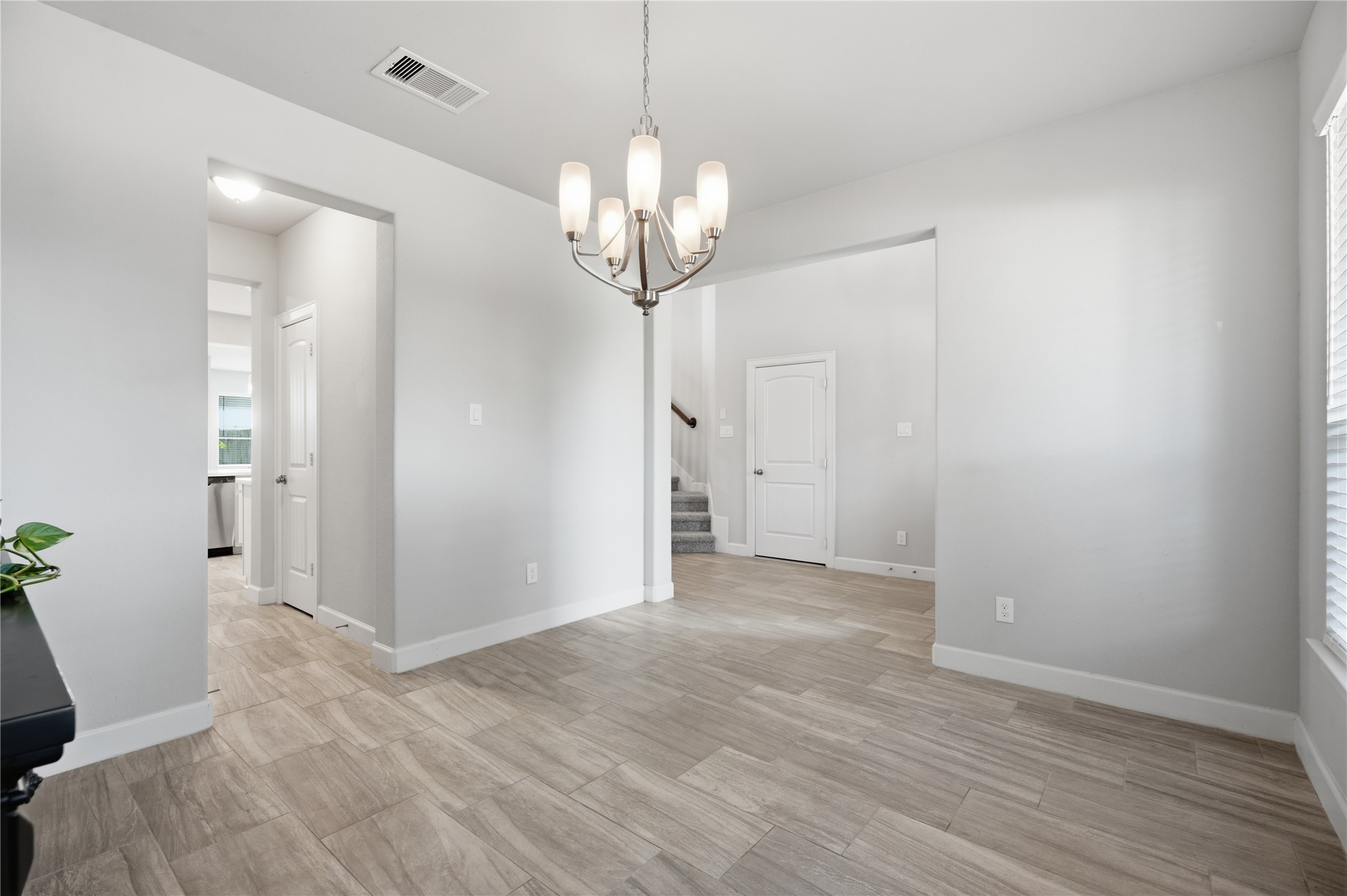 A closer look at the formal dining room featuring tile flooring, abundant natural light, neutral finishes, and convenient access to the kitchen and main living spaces.