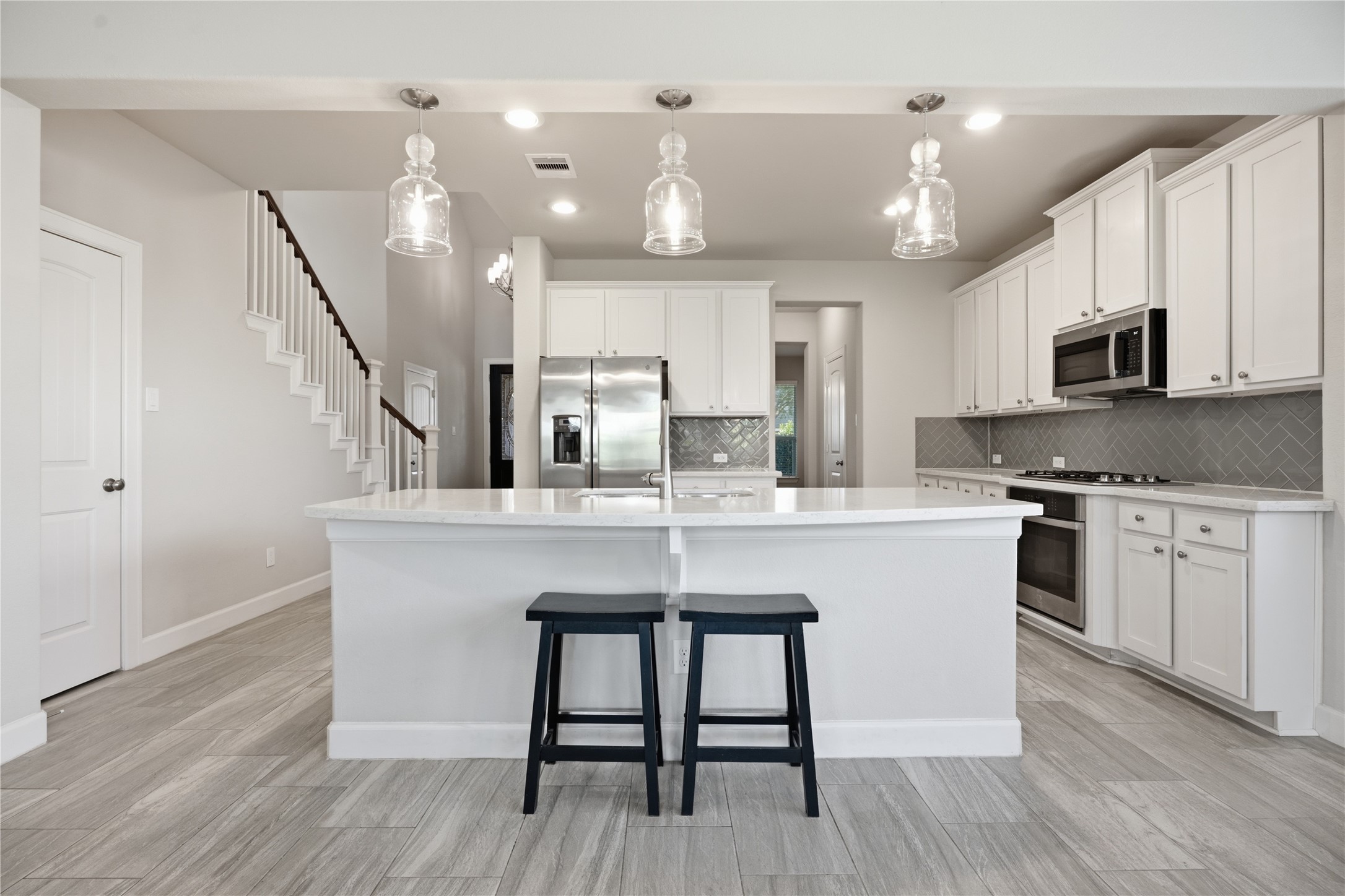 Spacious kitchen featuring stainless steel appliances, abundant cabinetry, generous counter space, and a large center island.