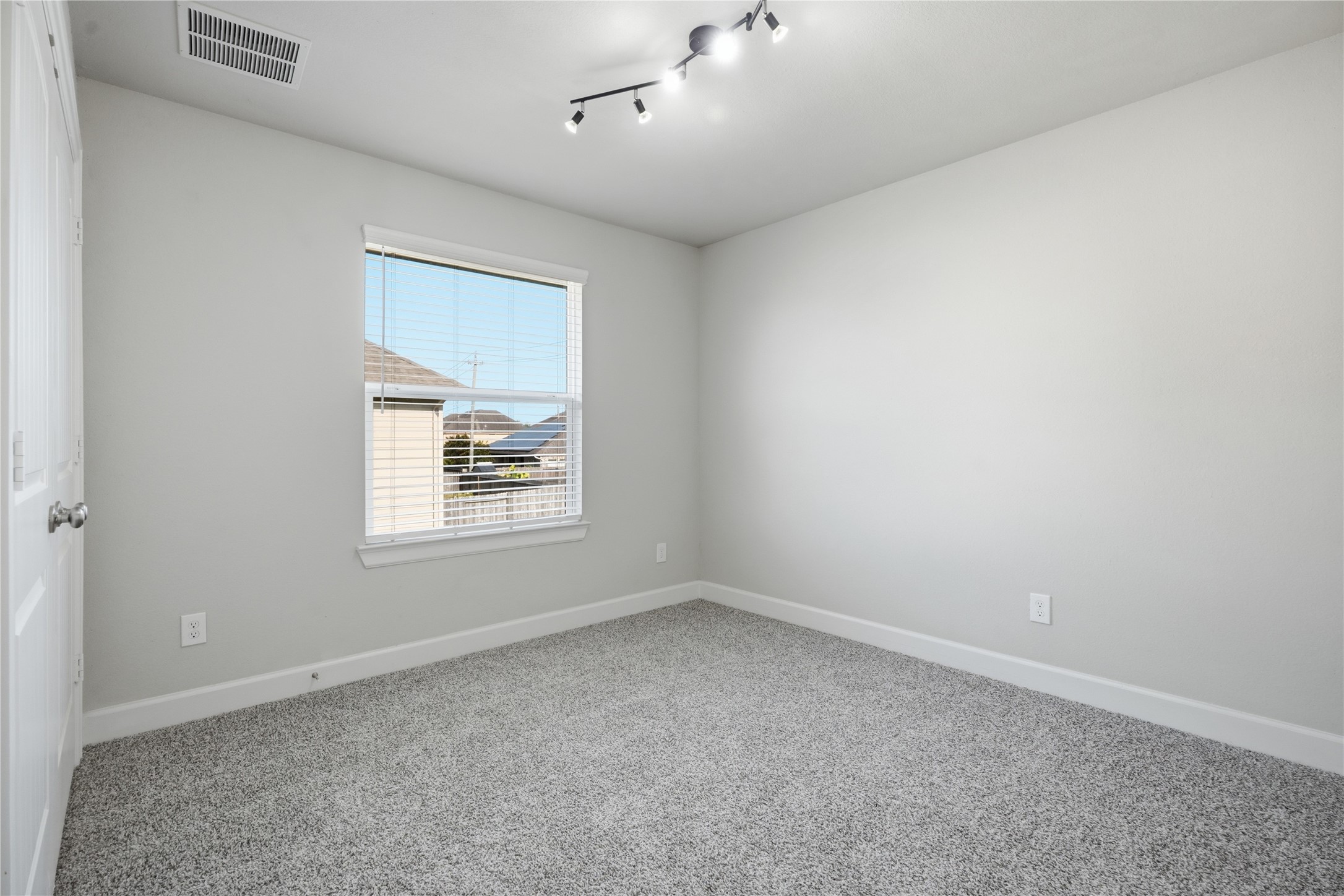 Spacious upstairs secondary bedroom with plenty of natural light and neutral finishes.