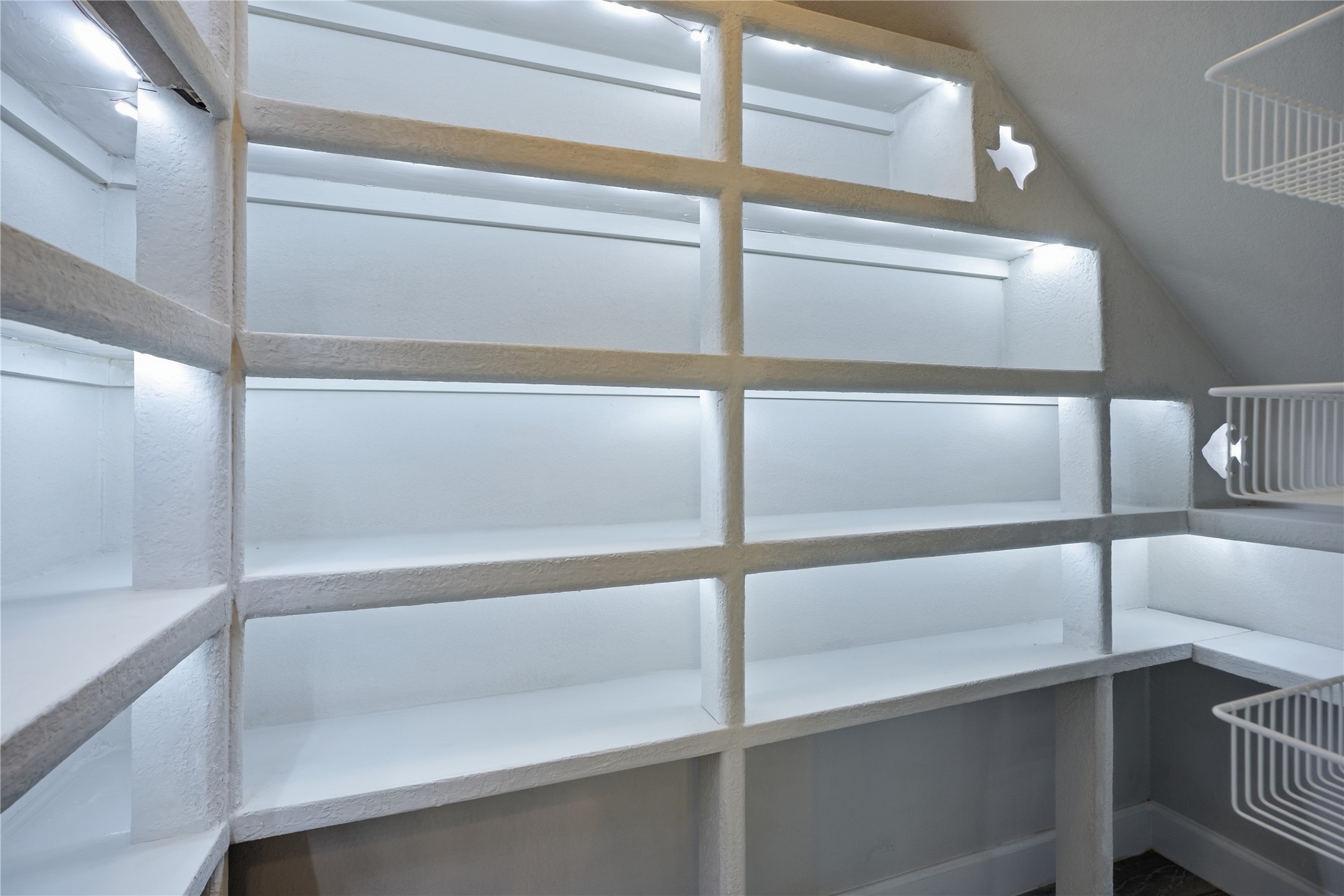 One of two kitchen pantries features a unique design with built-in lighting, adding both character and functionality to this thoughtfully designed storage space.