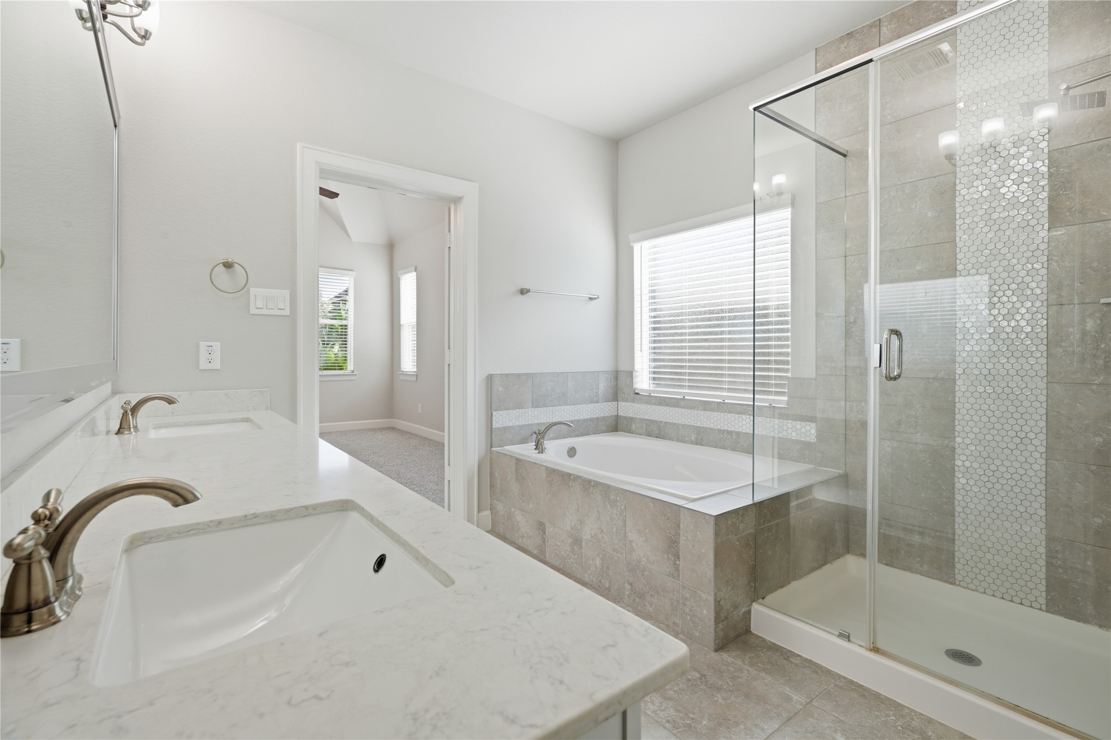 Another view highlights the separate shower and tub, along with the bathrooms spacious layout and neutral finishes.