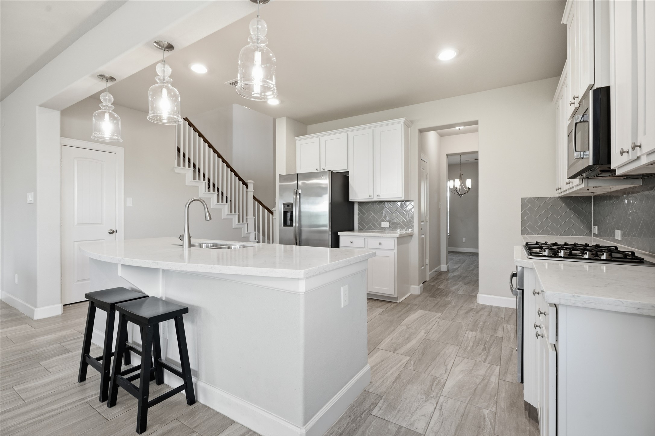 Open-concept design keeps the kitchen connected to the main living area, with a large island creating a natural gathering point between the two spaces.