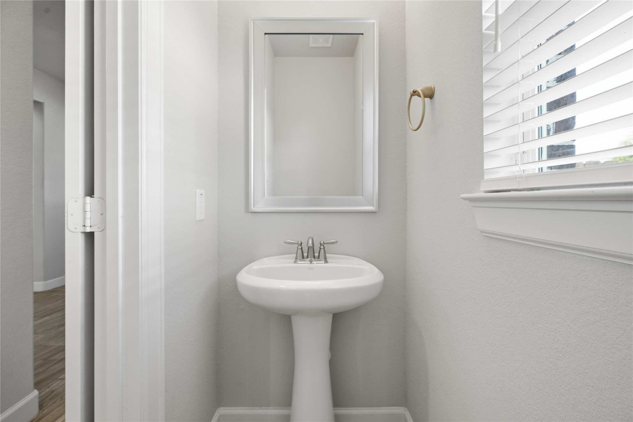 Conveniently located half bath downstairs features an updated vanity, mirror, and fixtures for a polished, modern look.