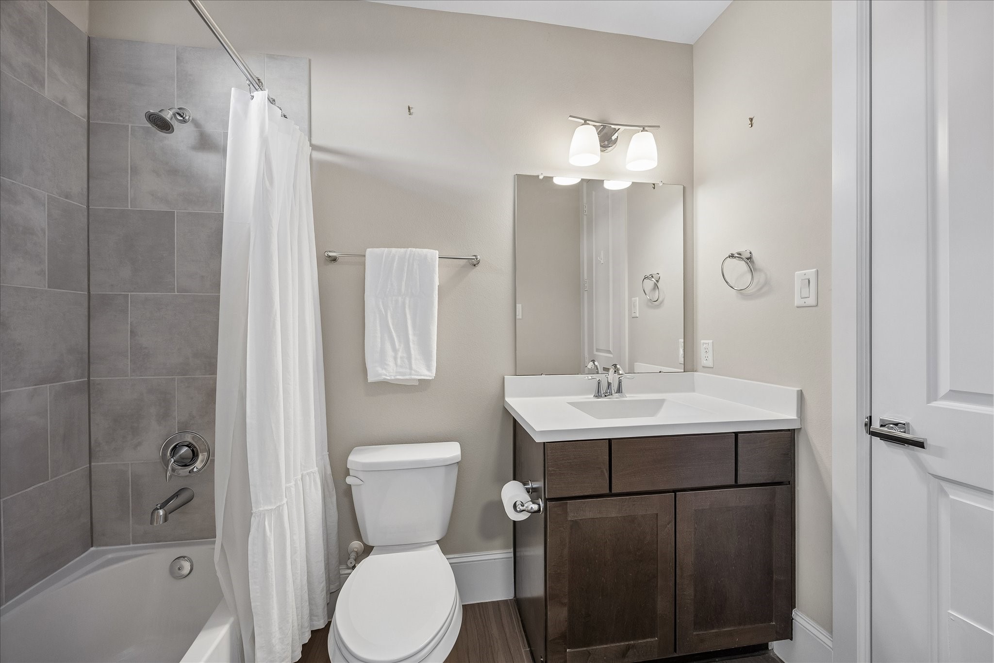 Private en suite bath serving the 1st floor secondary bedroom features a vanity w/ storage below, decorative vanity lighting & shower/tub combination w/ built-in soap niche. Privacy window provides natural light, while adjoining walk-in closet offers built-in hanging space. Wonderful functionality for guests or everyday use!