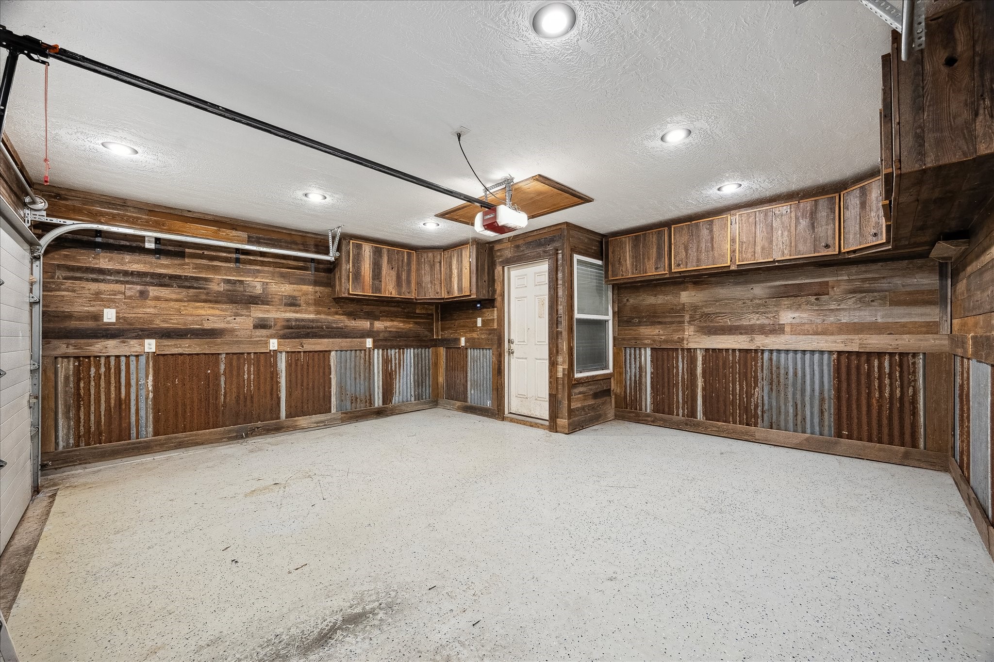 Garage features custom built shelving, plenty of storage