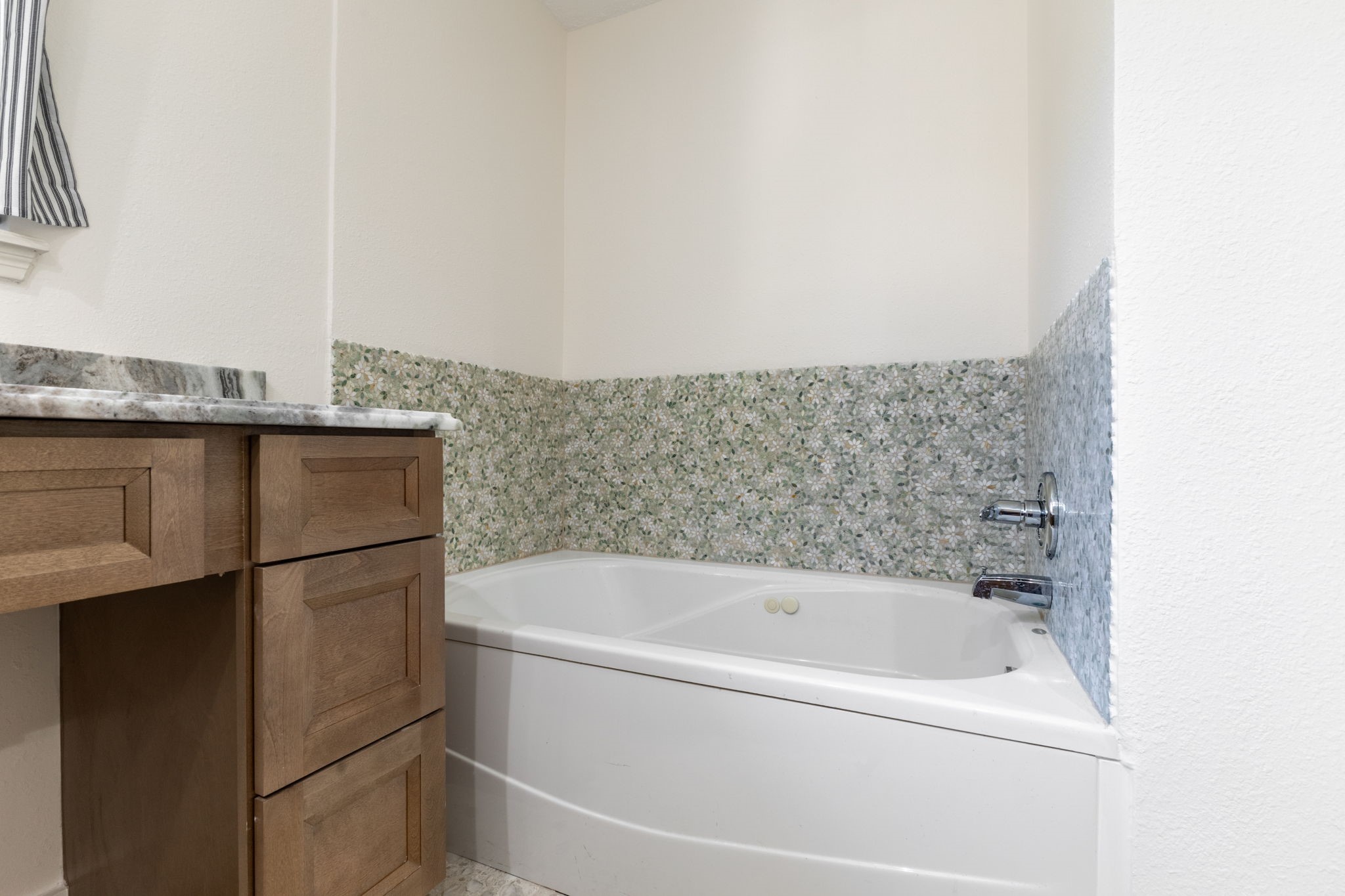 jetted tub with marble tile