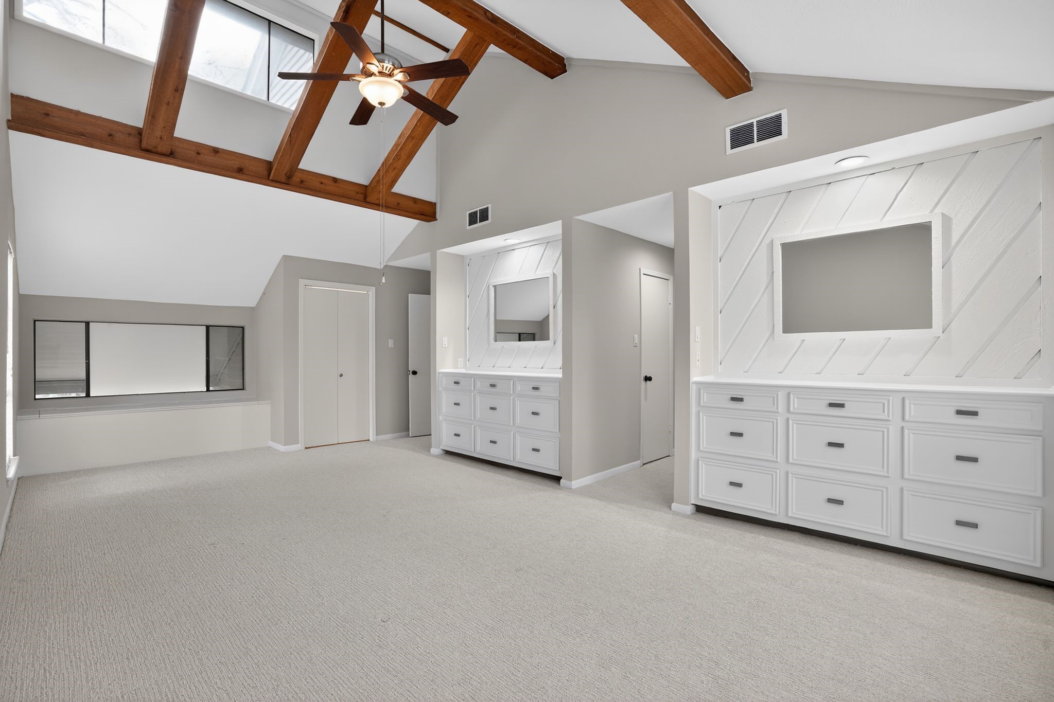 vaulted primary suite with built in dressers