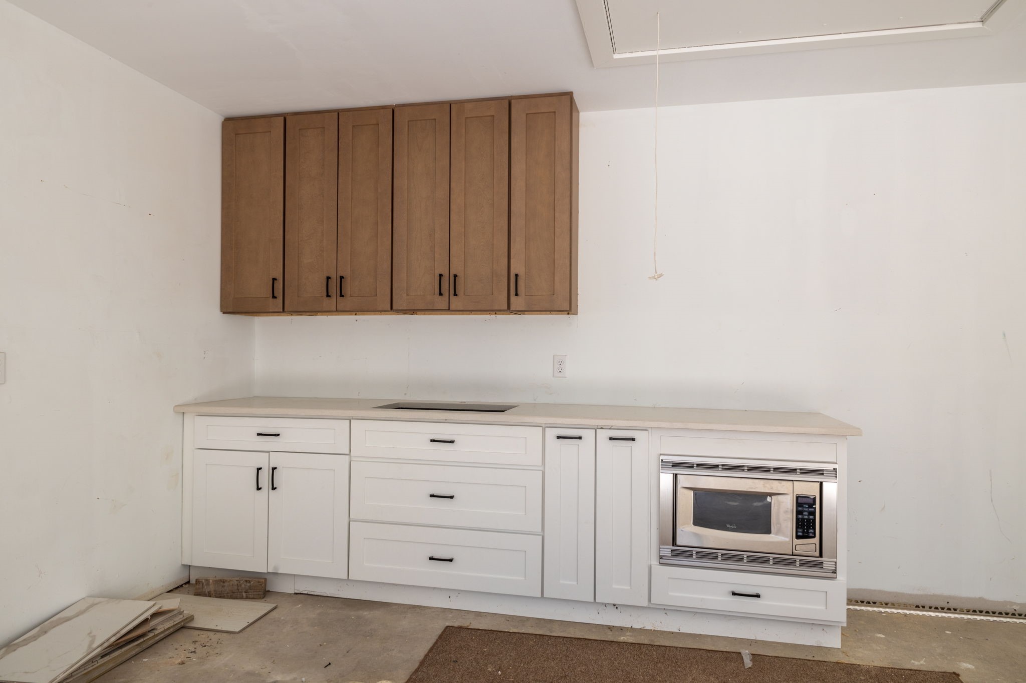 Cabinets in the garage with a place for a fridge.