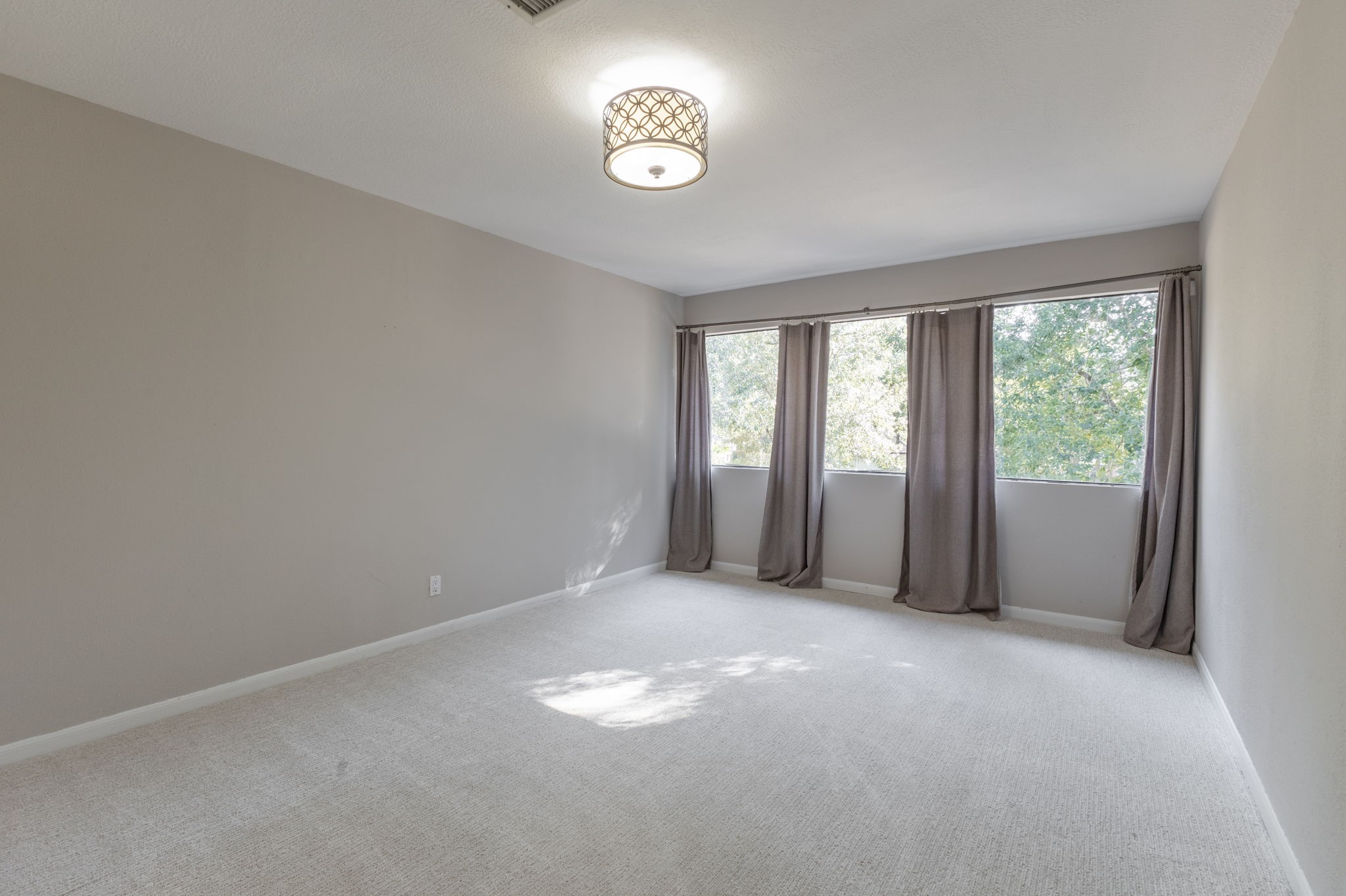 large bedroom upstairs with closet and wall of windows