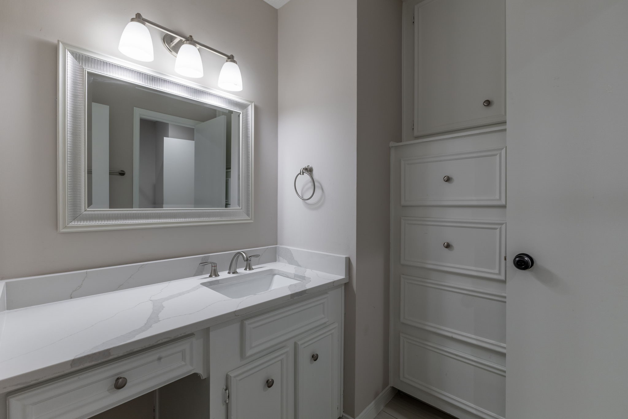 quartz countertops in secondary bathroom with build in dresser