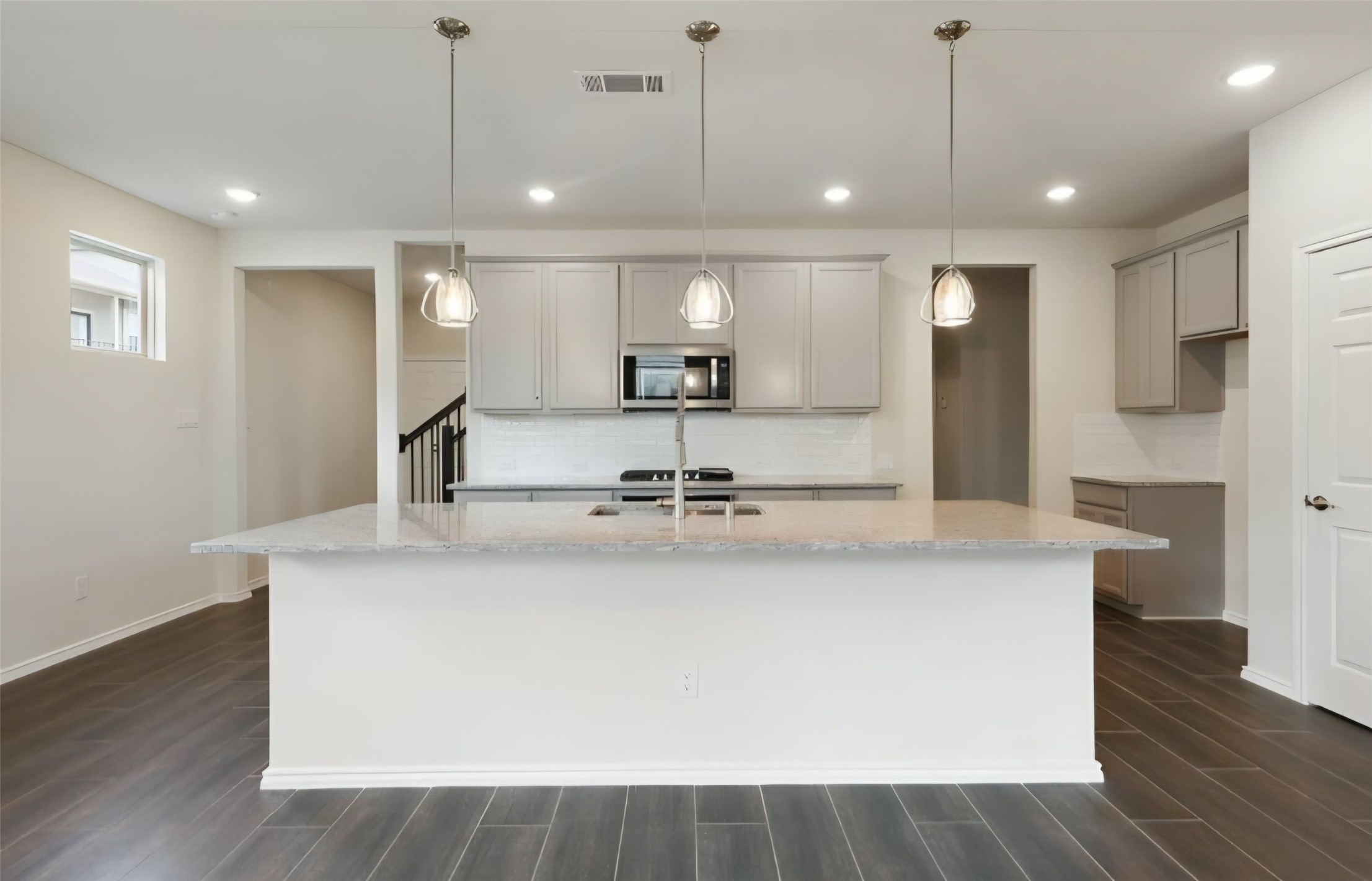 Kitchen island has elegant hanging pendant lighting