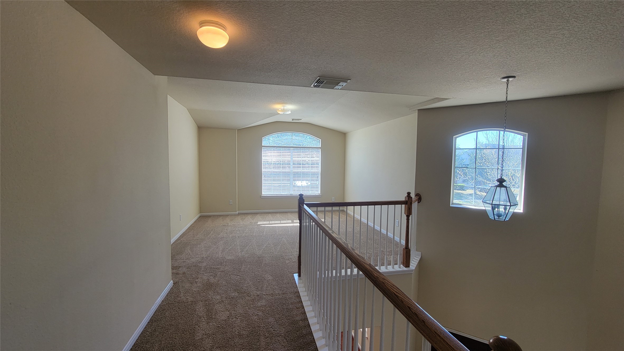 Upstairs features a spacious game room with an elegant view over the staircase.