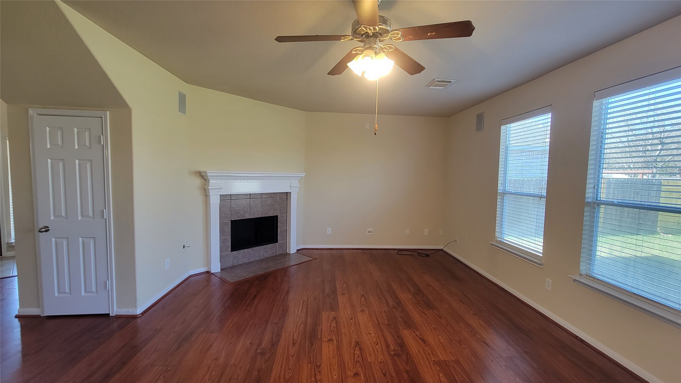 Cozy living room with a warm wooden floor and inviting fireplace.
