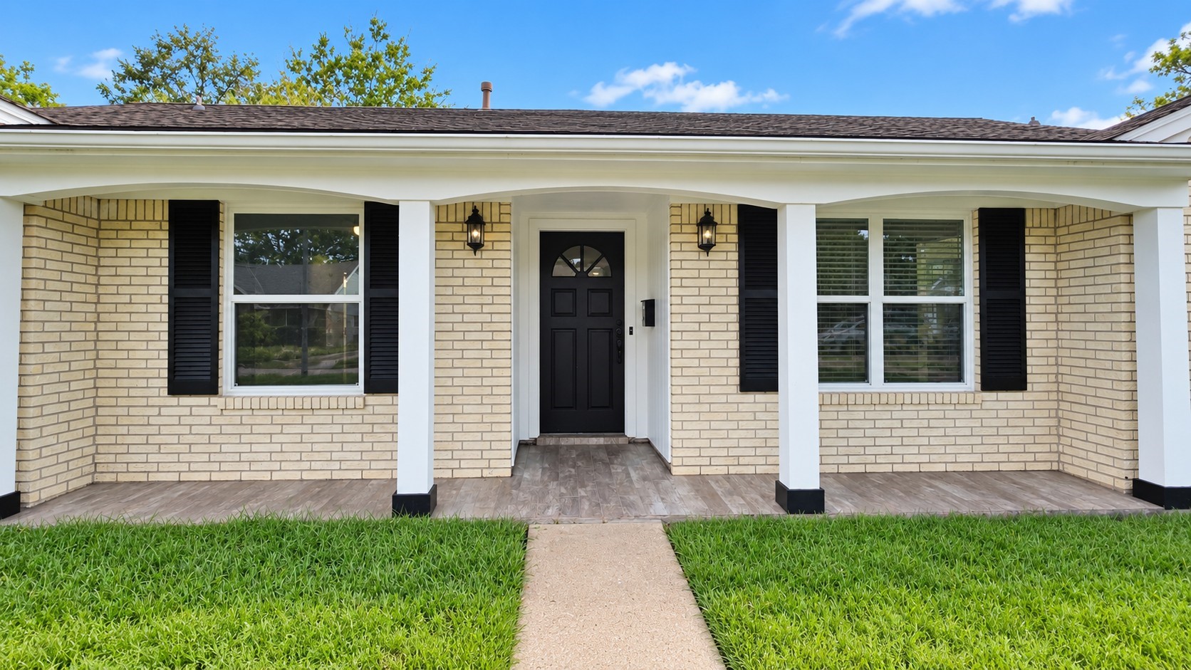 Charming single-story brick home with a welcoming covered front porch and timeless curb appeal.