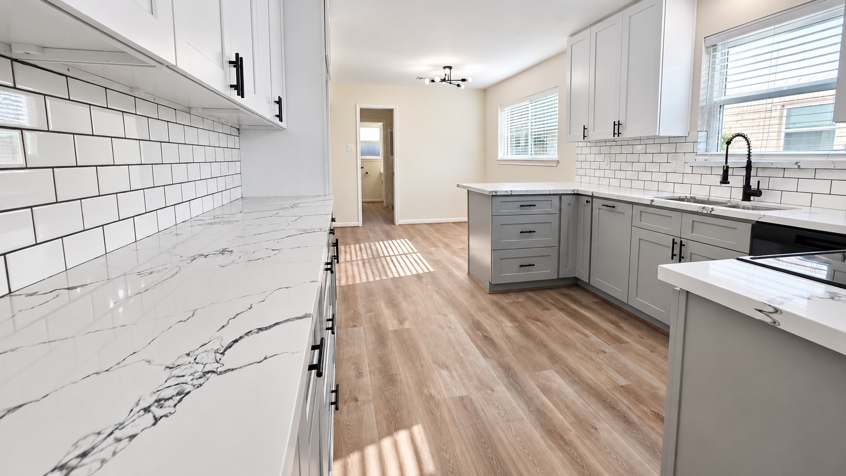 Sleek kitchen view highlights the subway-tile backsplash, veined countertops, and abundant cabinetry.