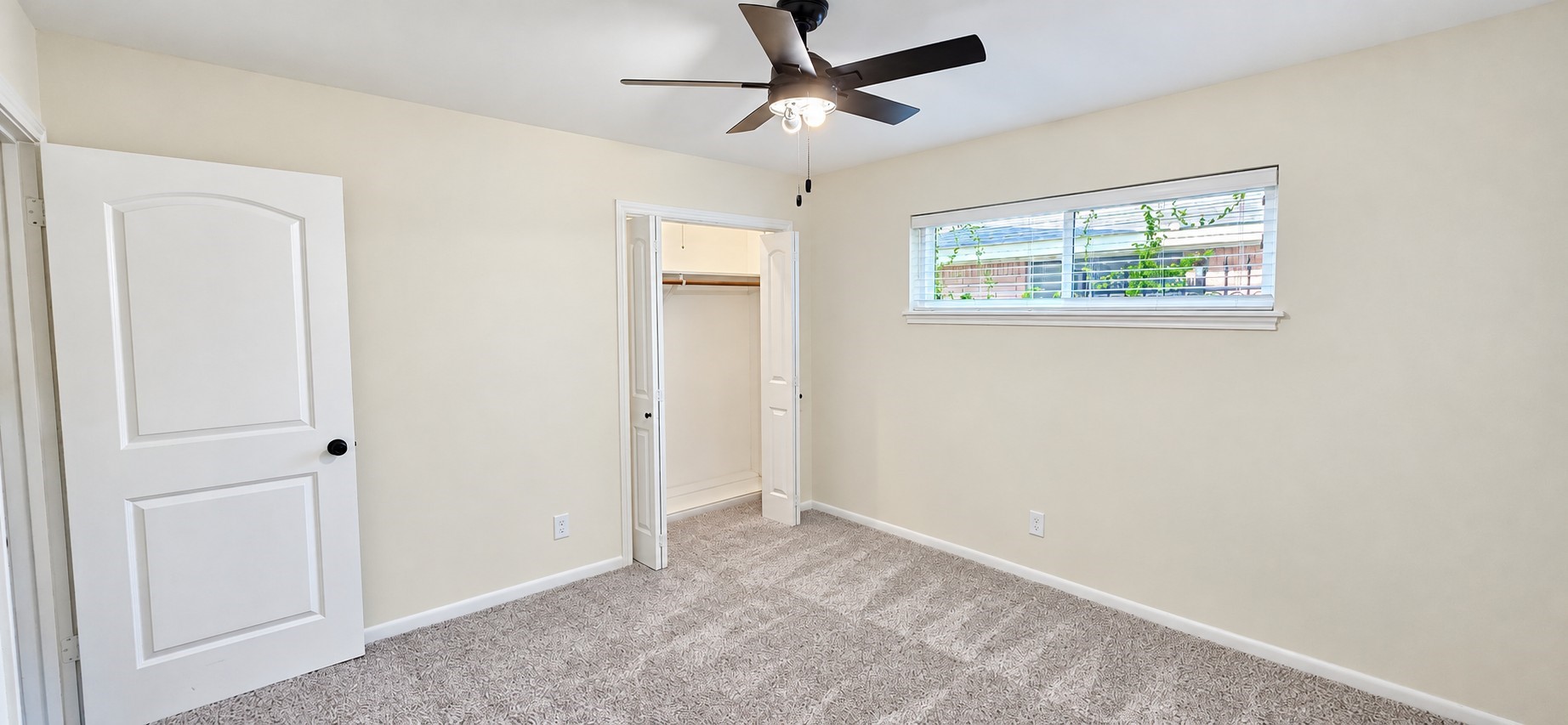 Bright secondary bedroom offers comfortable proportions, closet space, and a ceiling fan.