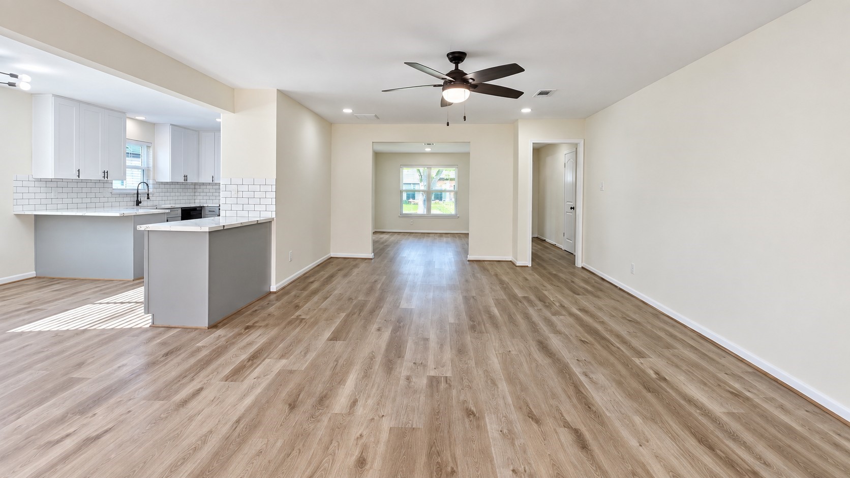 Another view of the open living space highlighting the generous footprint and connection to the kitchen.