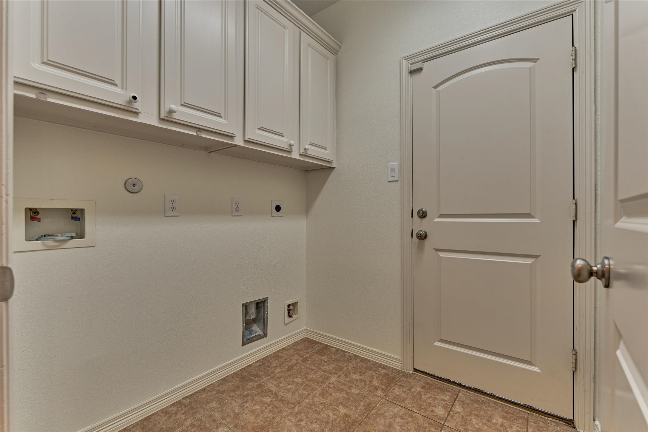 Laundry room off of the kitchen accesses the garage and has both electric and gas dryer hook ups along with cabinetry for storage.