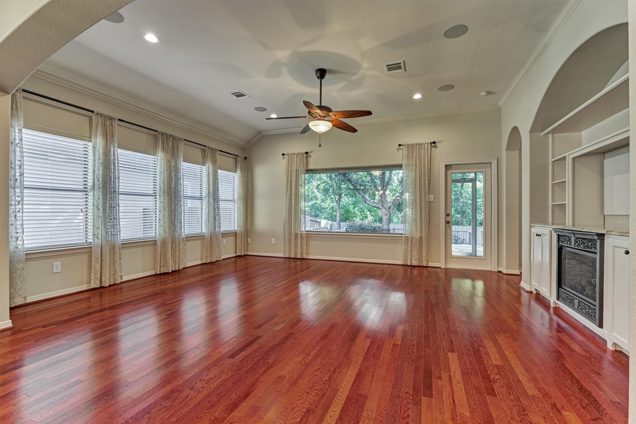 The bright living room is surrounded by windows for plenty of natural light.