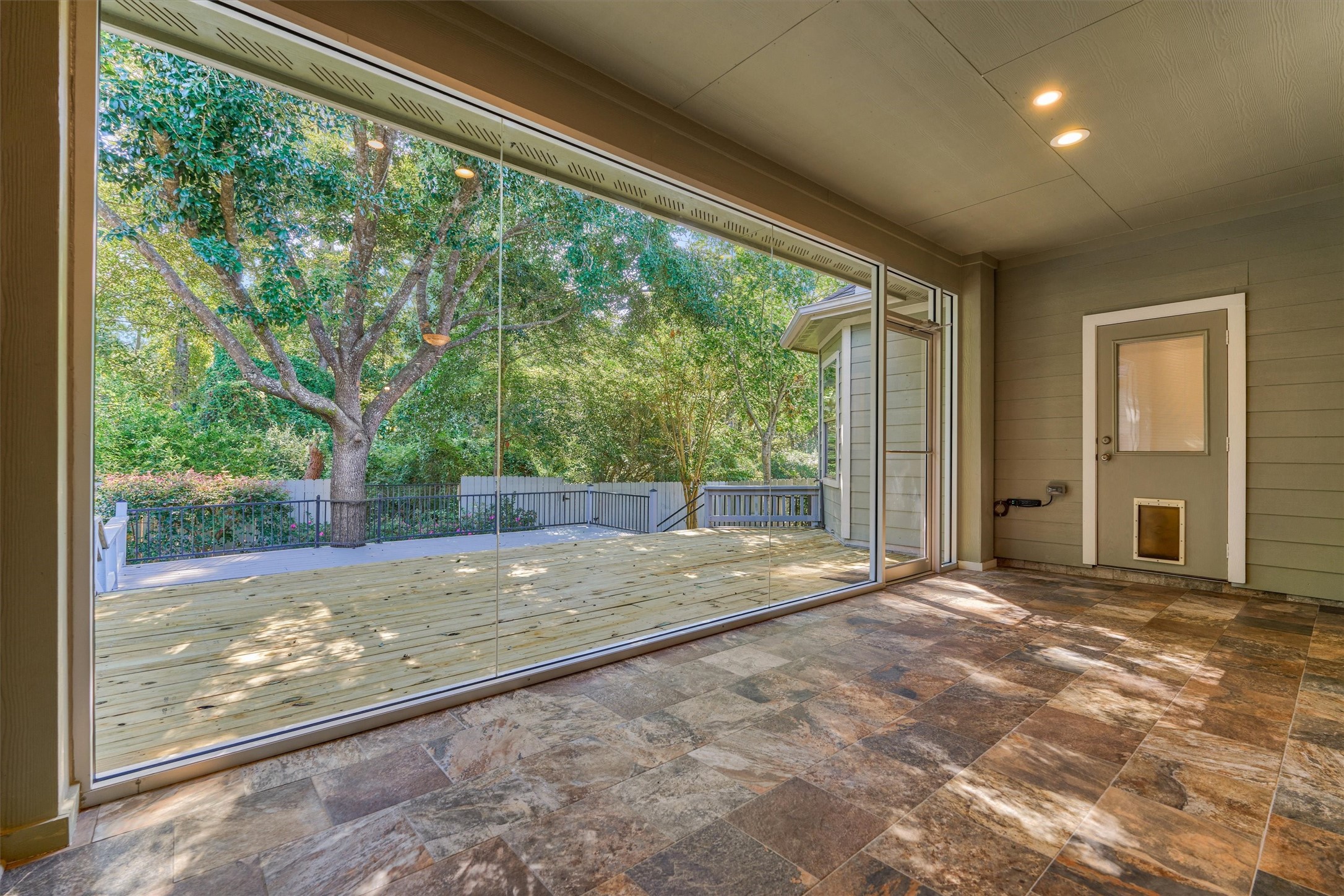 Seamless glass windows overlook the shaded and serene backyard!