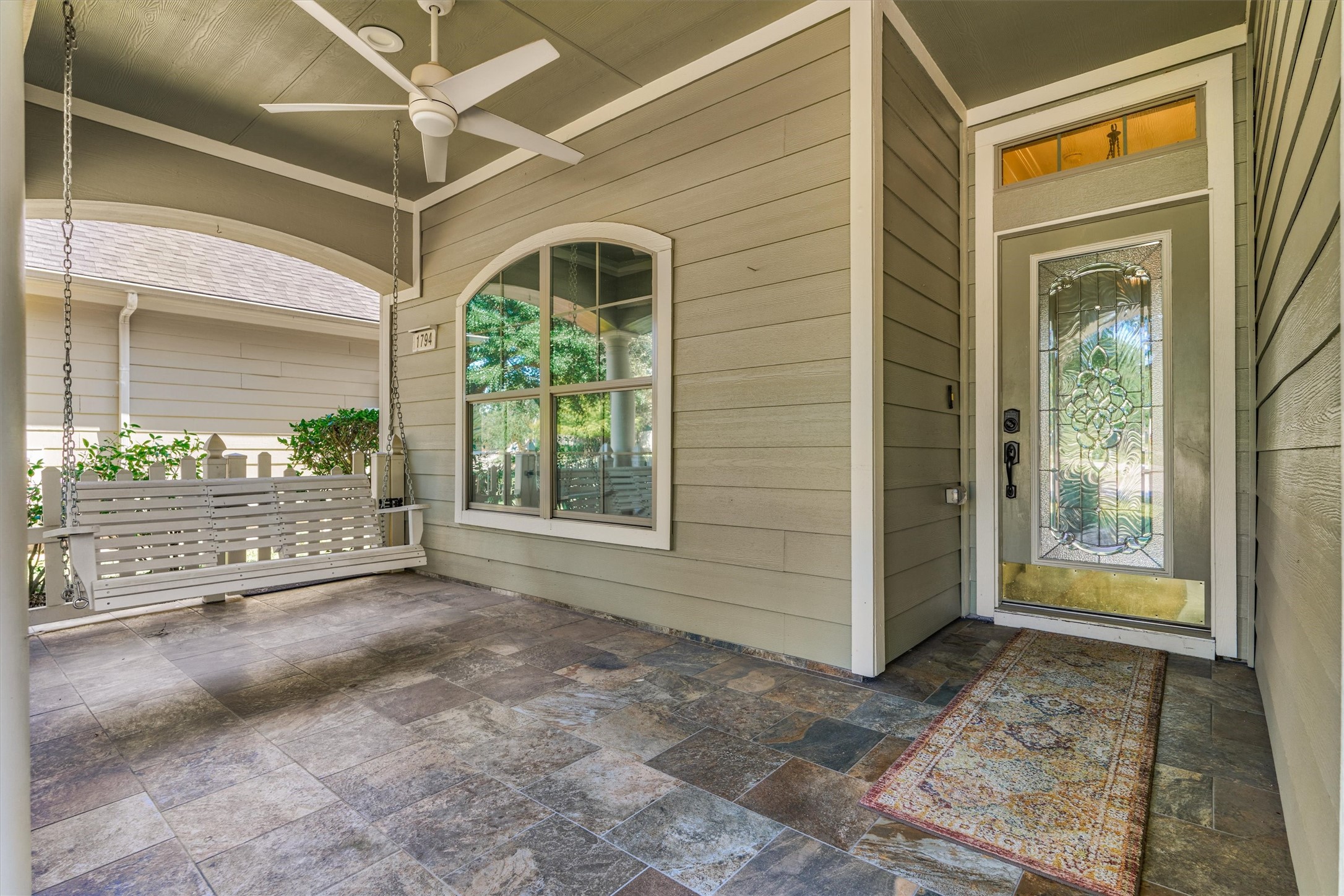 Large covered front porch with tile flooring and ceiling fan. Large covered front porch with tile flooring and ceiling fan.