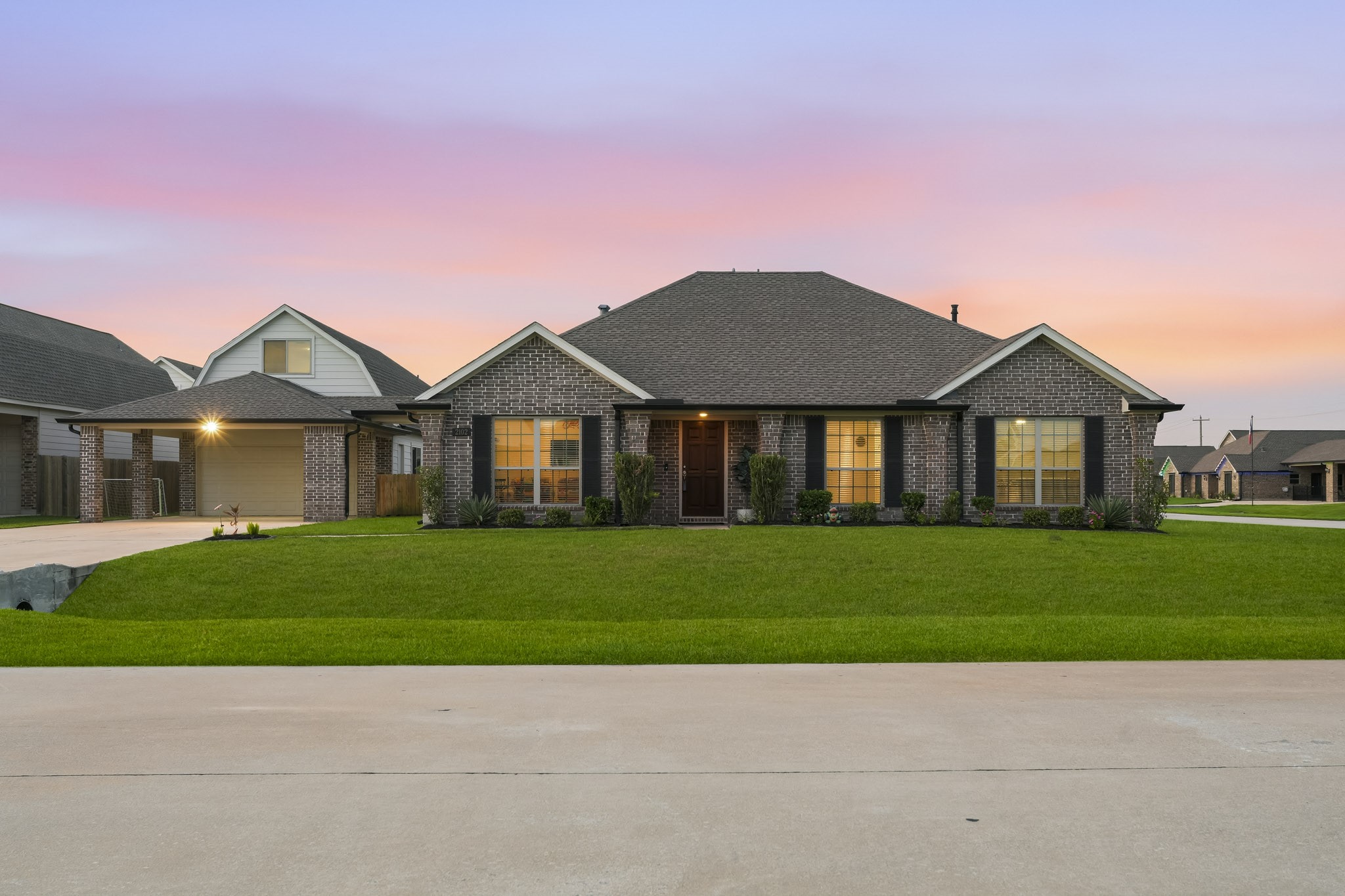 Twilight view of front of home featuring updated landscaping.