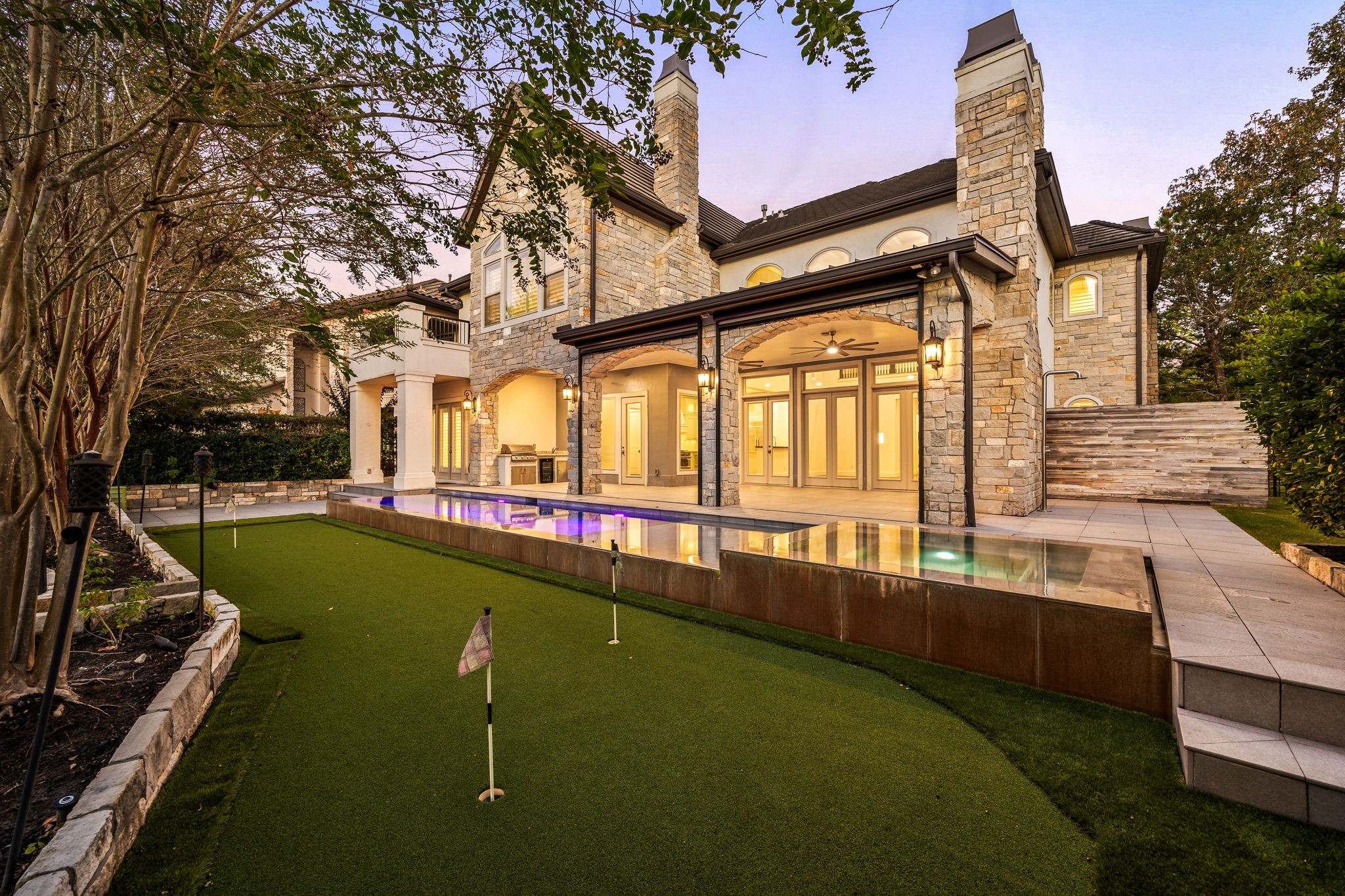 Welcome to an exceptional lakefront retreat in the prestigious Carlton Woods Creekside community, where timeless architecture meets resort style living. Featuring elegant stone and stucco exteriors, a sparkling pool and spa, private putting green, and expansive covered patio, this stunning residence offers the perfect setting for luxurious outdoor entertaining and relaxation.