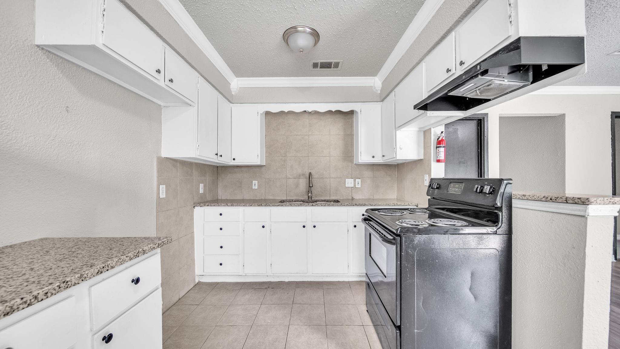 The kitchen pairs elegant granite countertops with a spacious breakfast bar, creating an inviting setting for casual dining and conversation. Tile flooring complements the space, offering timeless appeal and everyday practicality.