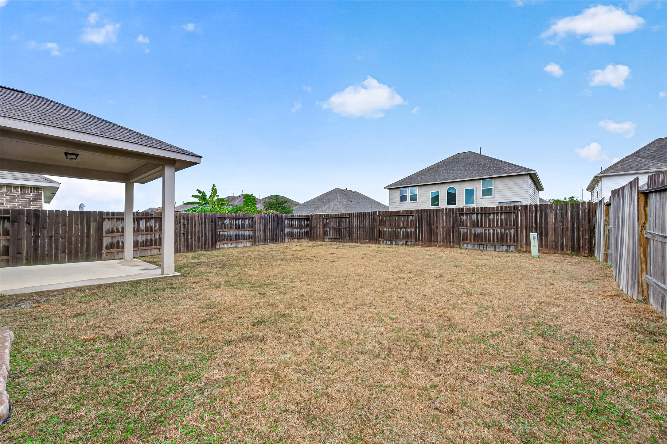 An additional backyard view shows the open lawn and its connection to the covered patio.