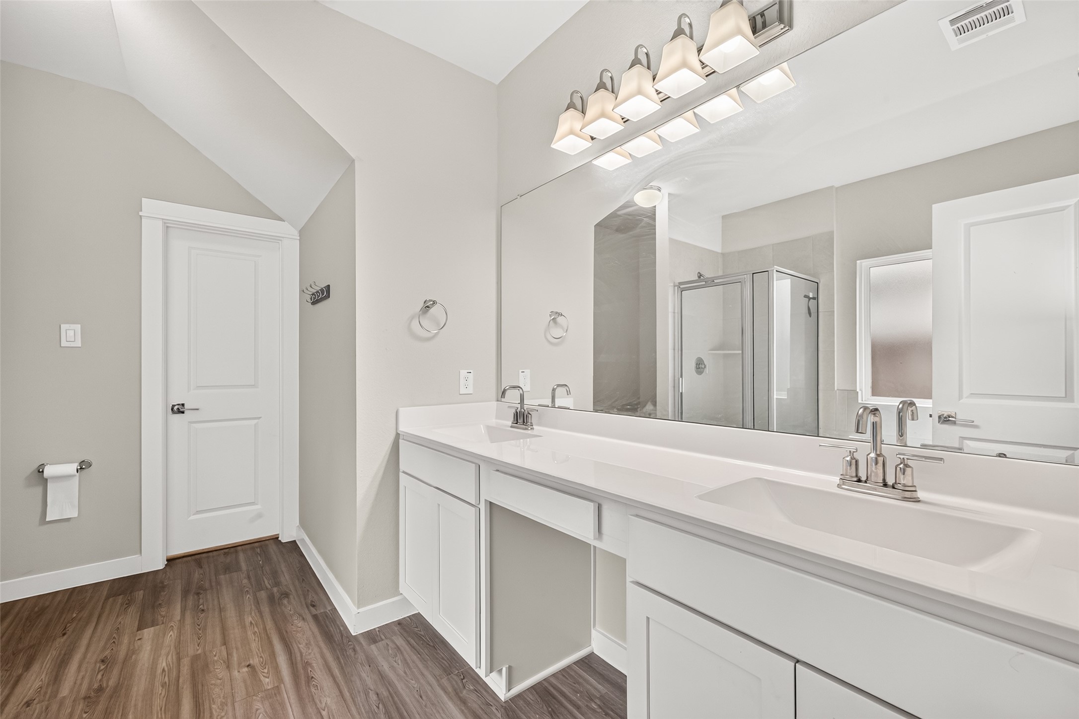 The primary bathroom features a double-sink vanity, generous counter space, and storage below.
